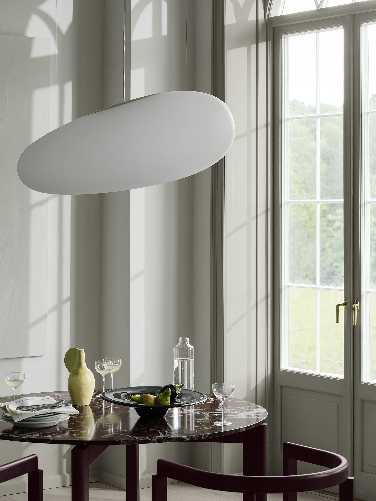 After Dinning Esstisch von Fritz Hansen mit Marmorplatte und passenden Stühlen unter einer modernen Pendelleuchte.