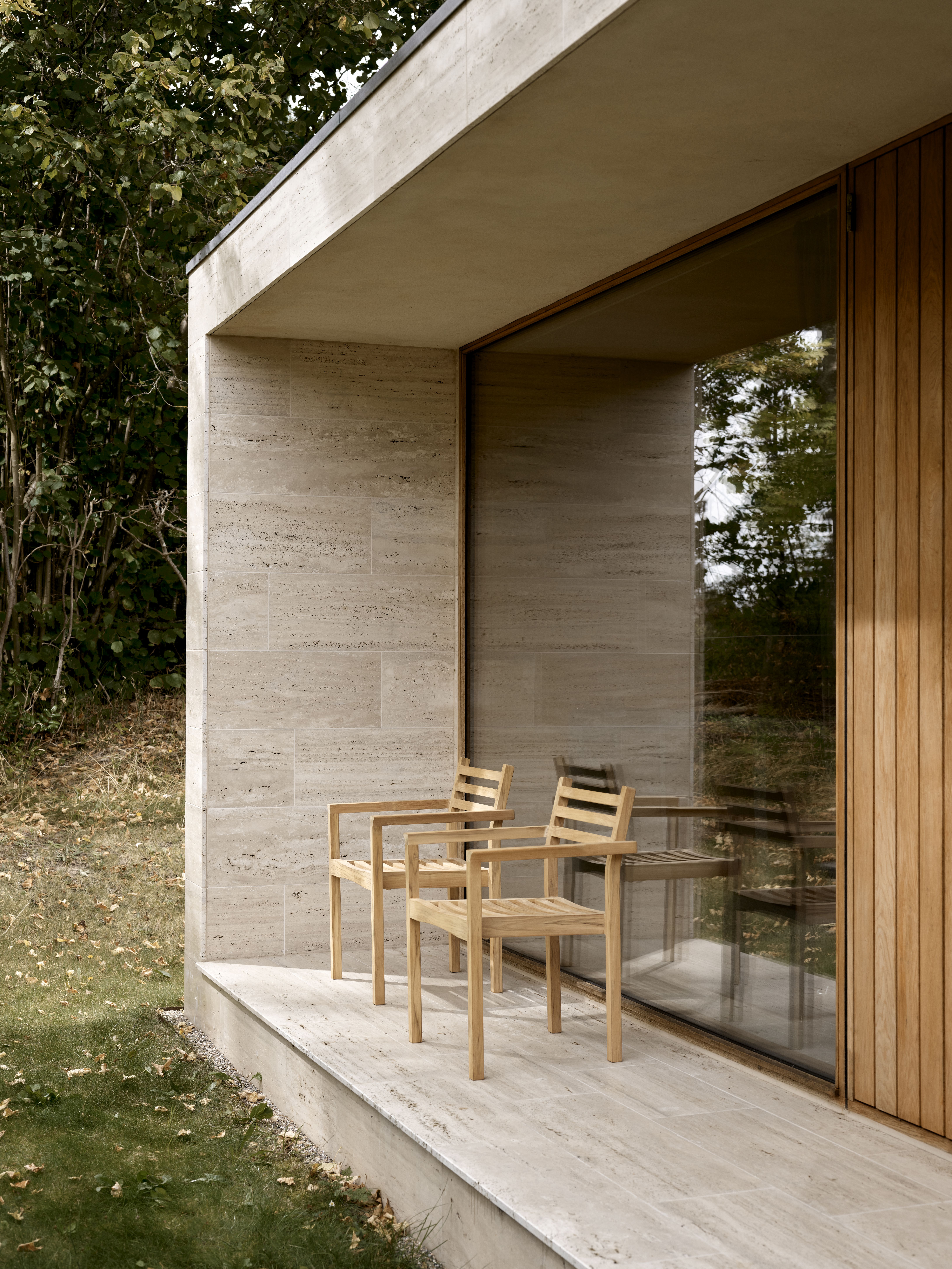 Zwei AH502 Teak Armlehnstühle von Carl Hansen & Søn auf einer Terrasse im Freien.