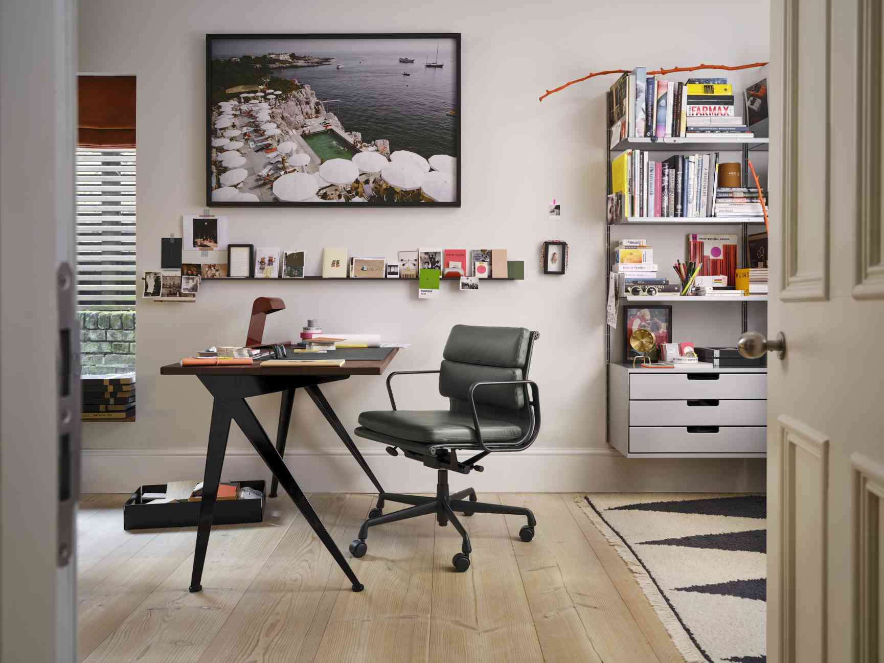 Nahaufnahme einer Vitra Tripod Clock Tischuhr auf einem Schreibtisch in einem modernen Arbeitszimmer.