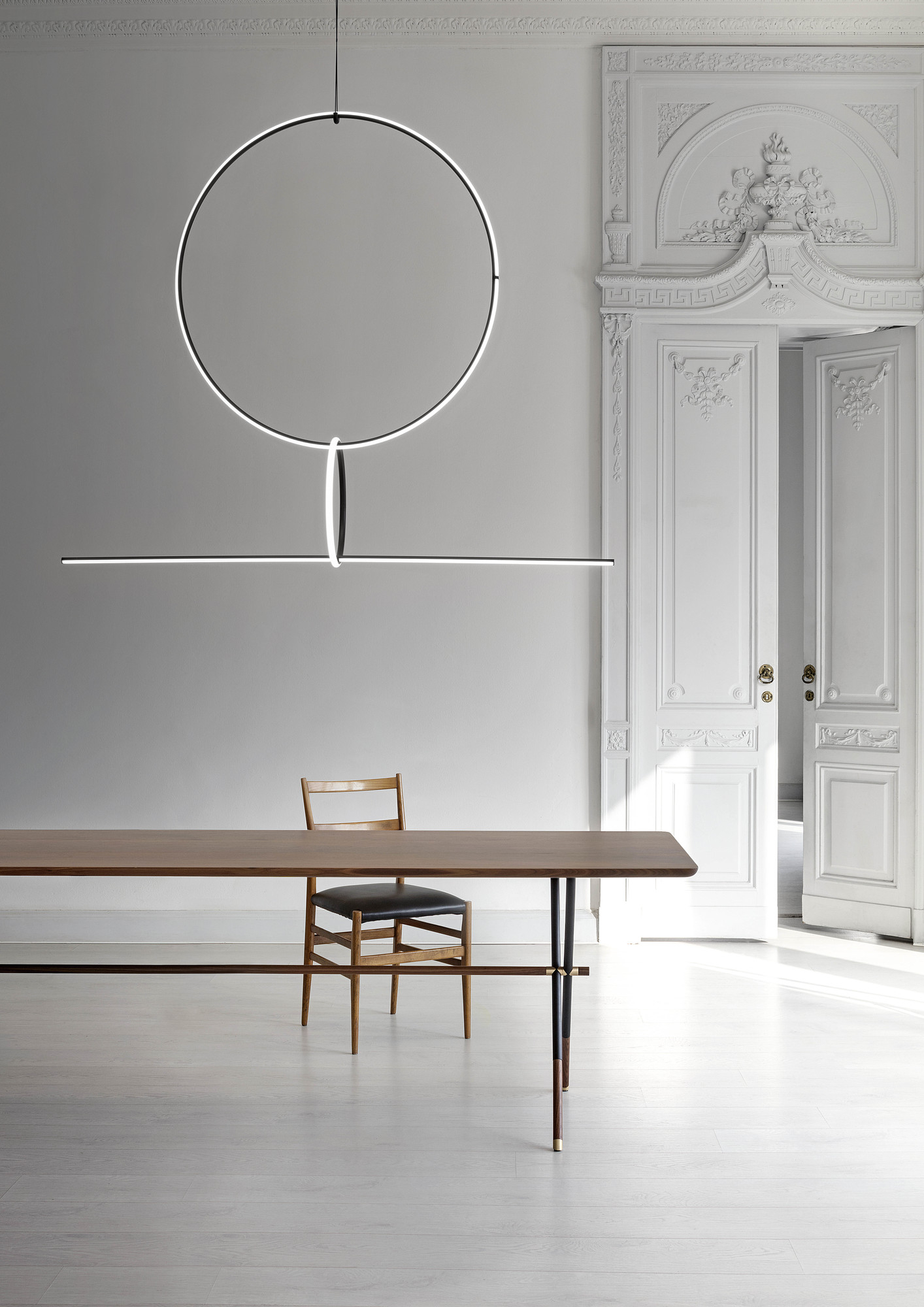 Moderne Flos Arrangements Pendelleuchte über Esstisch mit Stuhl in stilvollem, hellem Interieur. Design Hängeleuchte.