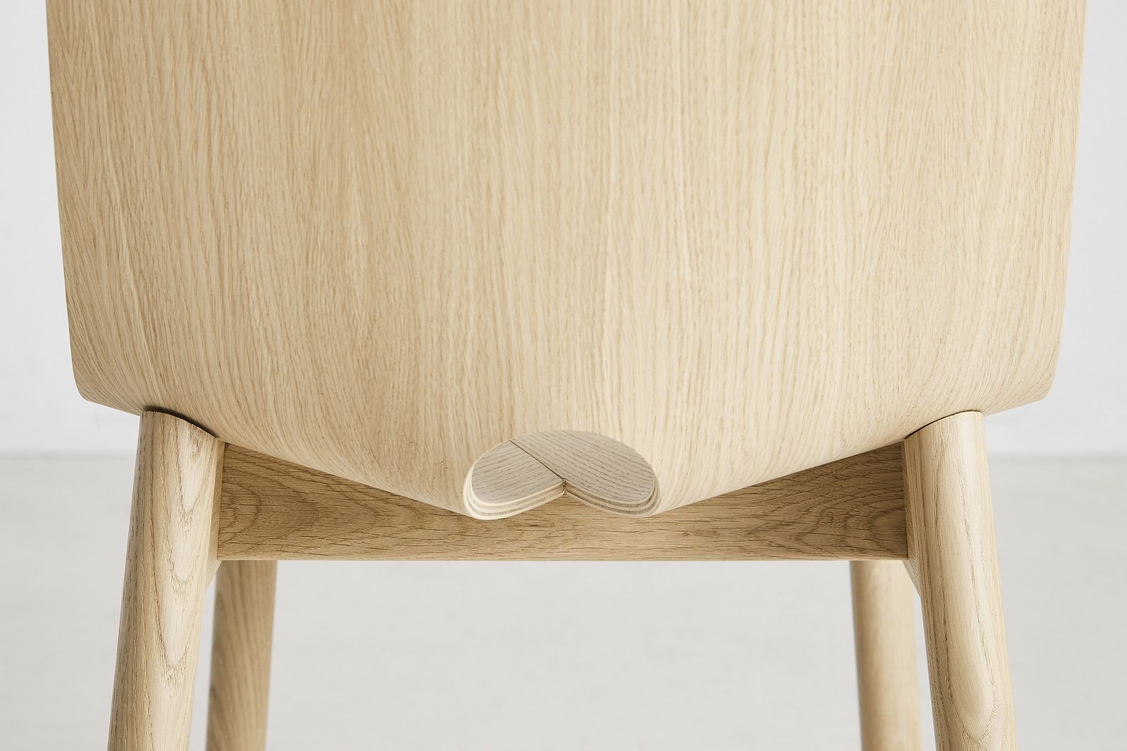 Detailansicht des hellen Holzstuhls Mono von Woud, minimalistisches Design mit Fokus auf natürliche Materialien.