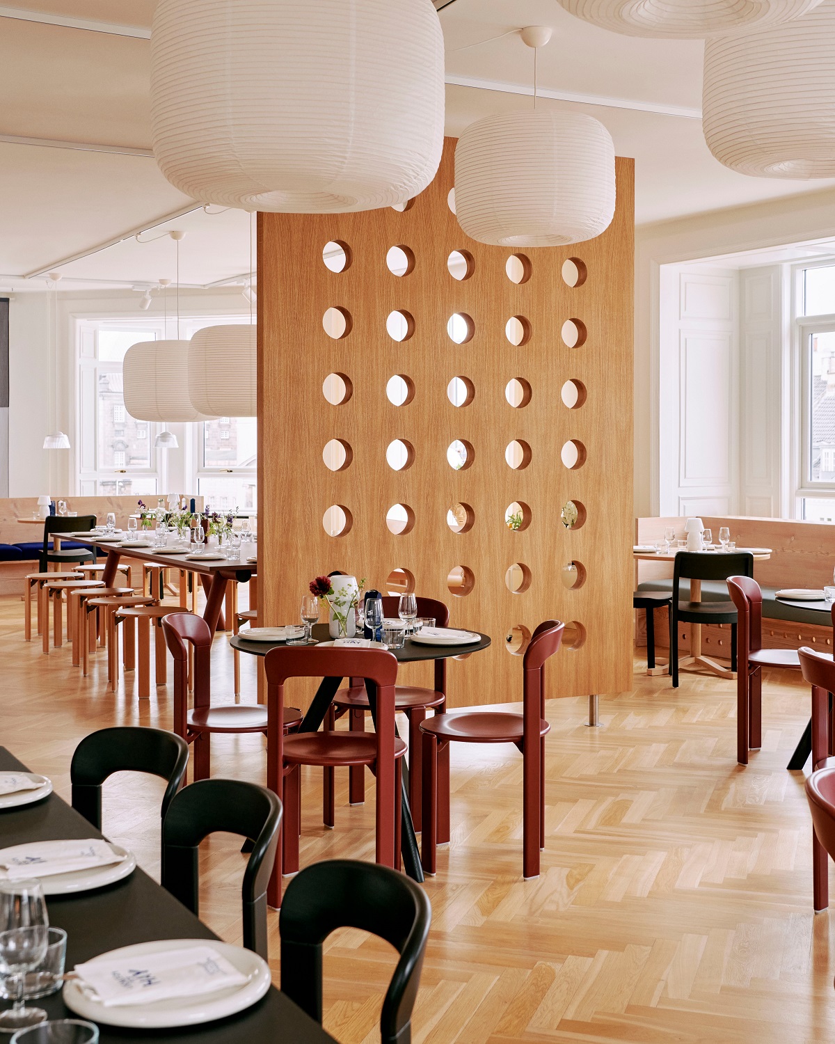 Helle Innenaufnahme eines Restaurants mit mehreren Hay Paper Shade-Donut Lampenschirmen in klassischem Weiß.