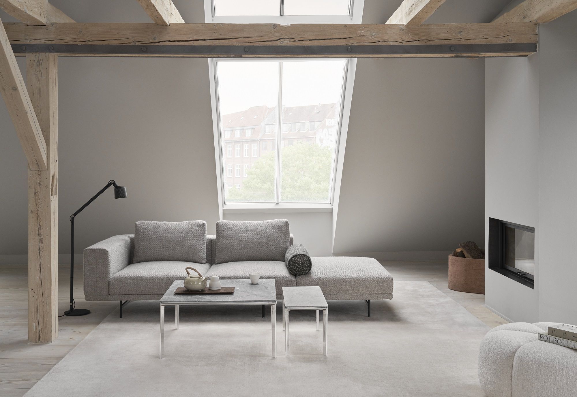 Vipp Coffee Table Square im modernen Wohnzimmer mit grauem Sofa und Kamin.