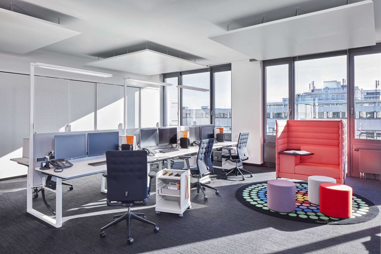 Büro mit Schreibtischen, Bürostühlen und einem weißen Vitra Follow Me Rollcontainer für Bürobedarf im Vordergrund.