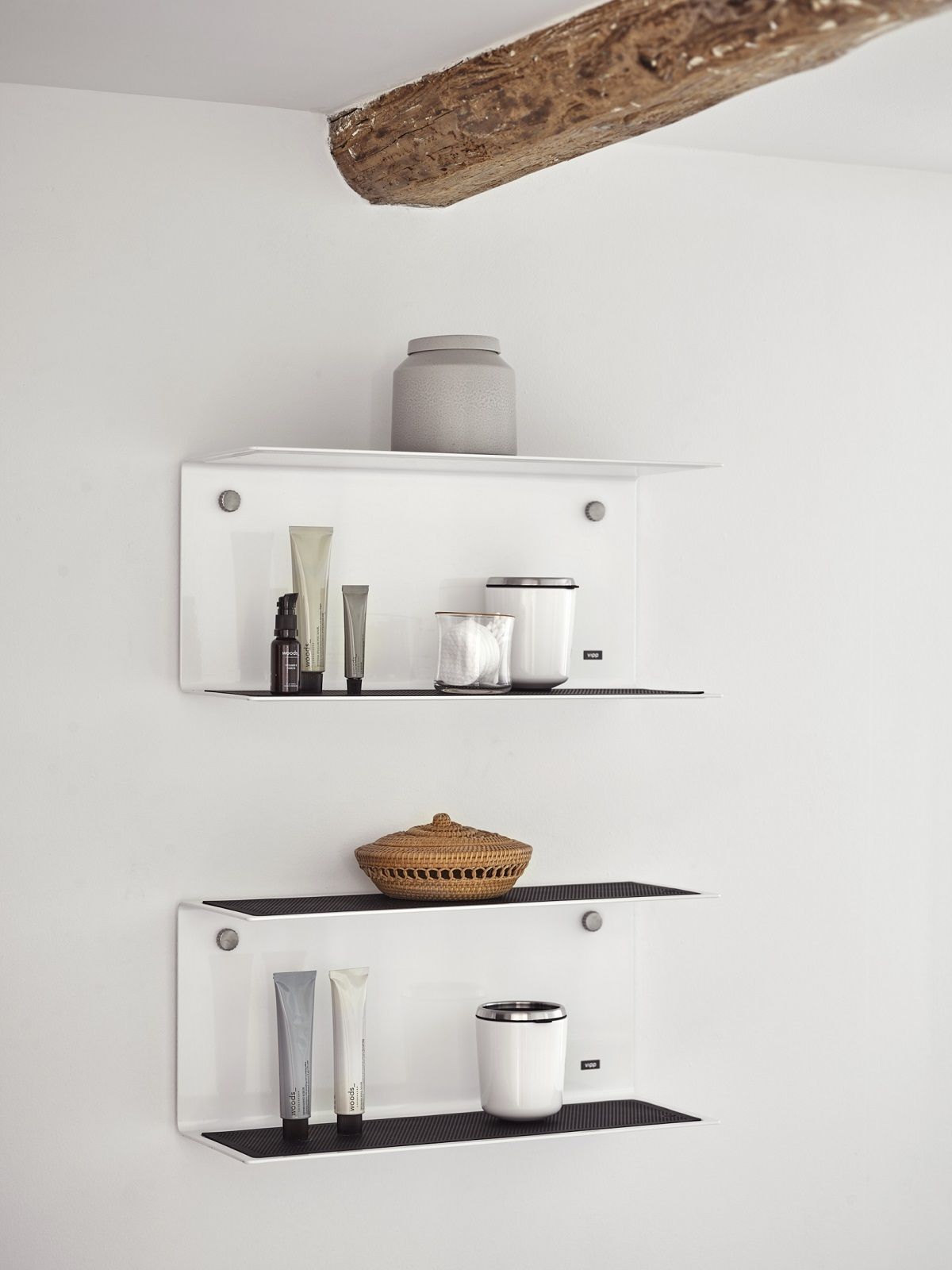Zwei weiße Vipp U-Form Wandregale mit Badaccessoires an einer weißen Wand mit Holzbalken.