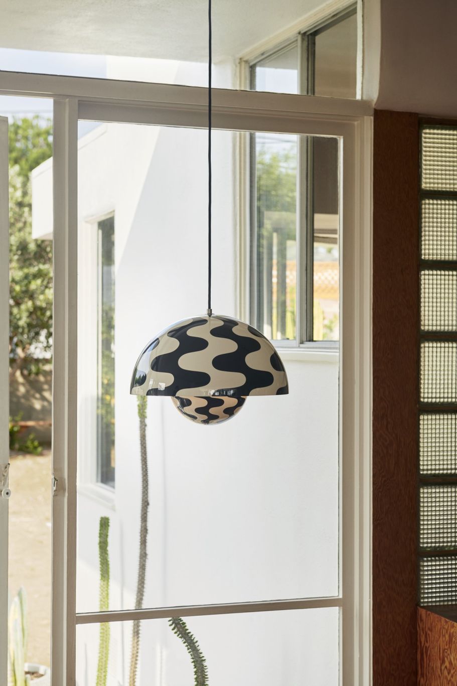 Flowerpot Pendelleuchte von AndTradition mit schwarz-weißem Wellenmuster, hängend vor einem Fenster. Design Lampe für Wohnraum.