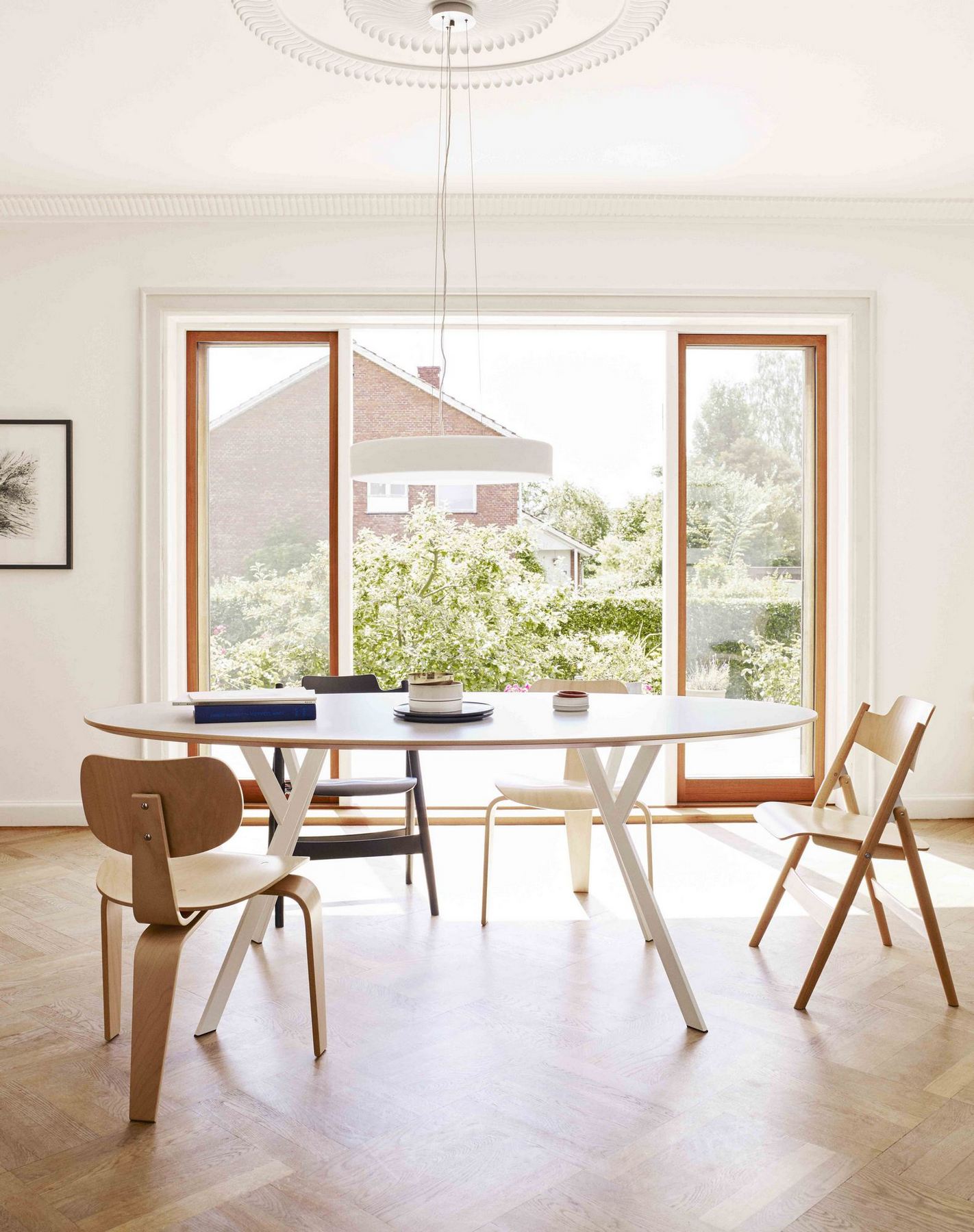 Esszimmer mit ovalem Tisch und mehreren SE 42 Stühlen von Wilde+Spieth in hellem Holz.