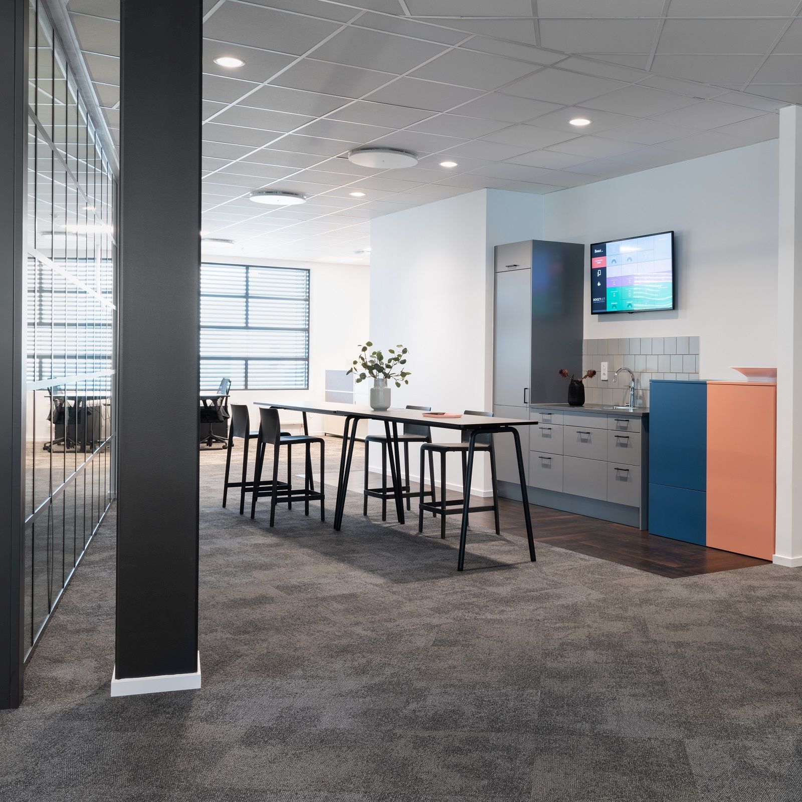 Büroküche mit Exhibit Bin Mülleimer zur Mülltrennung in Blau und Orange neben grauer Küchenzeile.