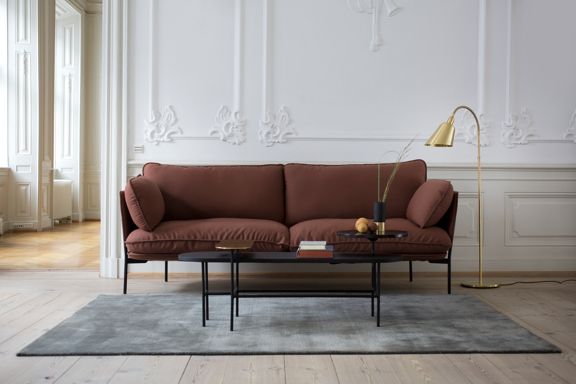 AndTradition Cloud Sofa, 3-Sitzer in Braun, modernes Wohnzimmer mit Teppich, Tisch und Stehlampe.