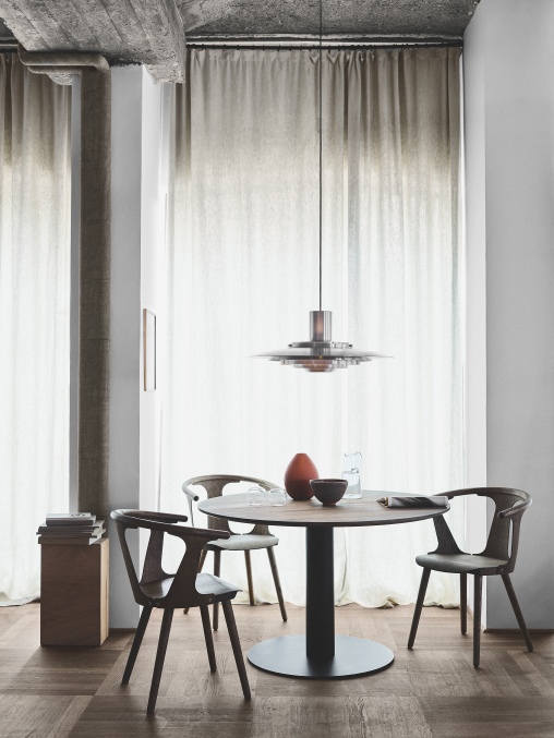 Esszimmer mit rundem Tisch und drei schwarzen In Between Stühlen SK1 von AndTradition.
