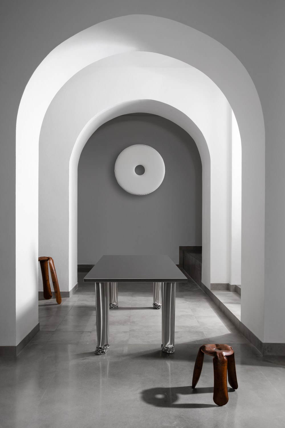 Crash Table Esstisch von Zieta im minimalistischen Raum mit Bögen und Holzstühlen, modernes Design.