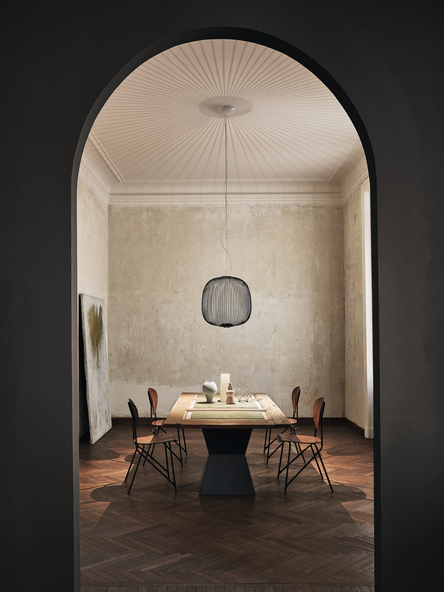Esszimmer mit Foscarini Spokes Pendelleuchte in Kupfer über einem Holztisch.