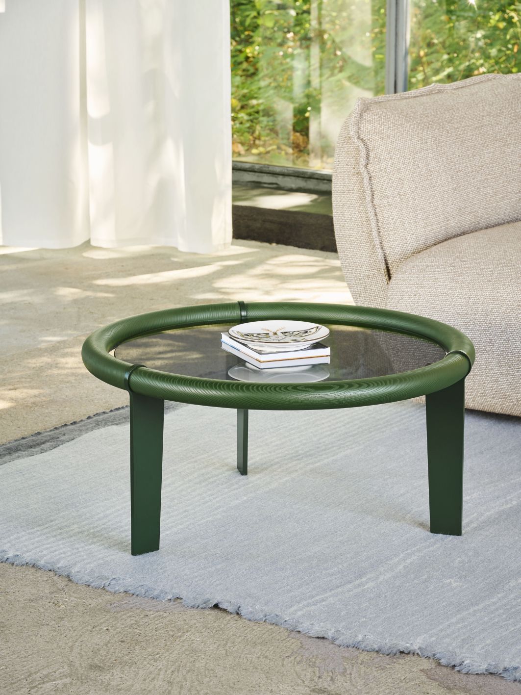 Boia Couchtisch: Runder, grüner Couchtisch mit Glasplatte und Dekoration im modernen Wohnzimmer.