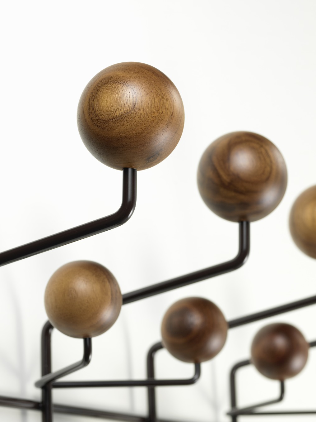 Detailaufnahme der Eames Hang it all Garderobe von Vitra mit bunten Holzkugeln in Nussbaum.
