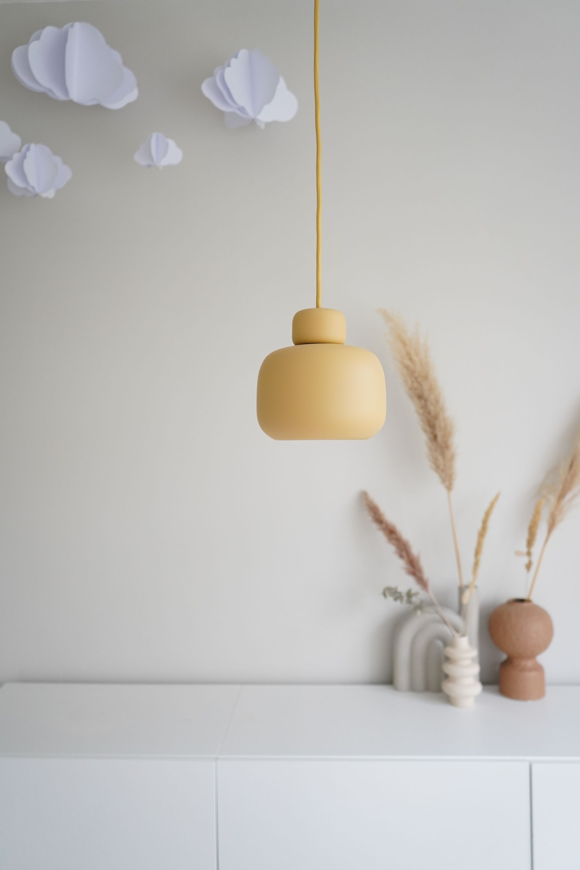 Nahaufnahme der Stone Pendelleuchte von Woud in Gelb, modernes Design für Wohnzimmer und Schlafzimmer.