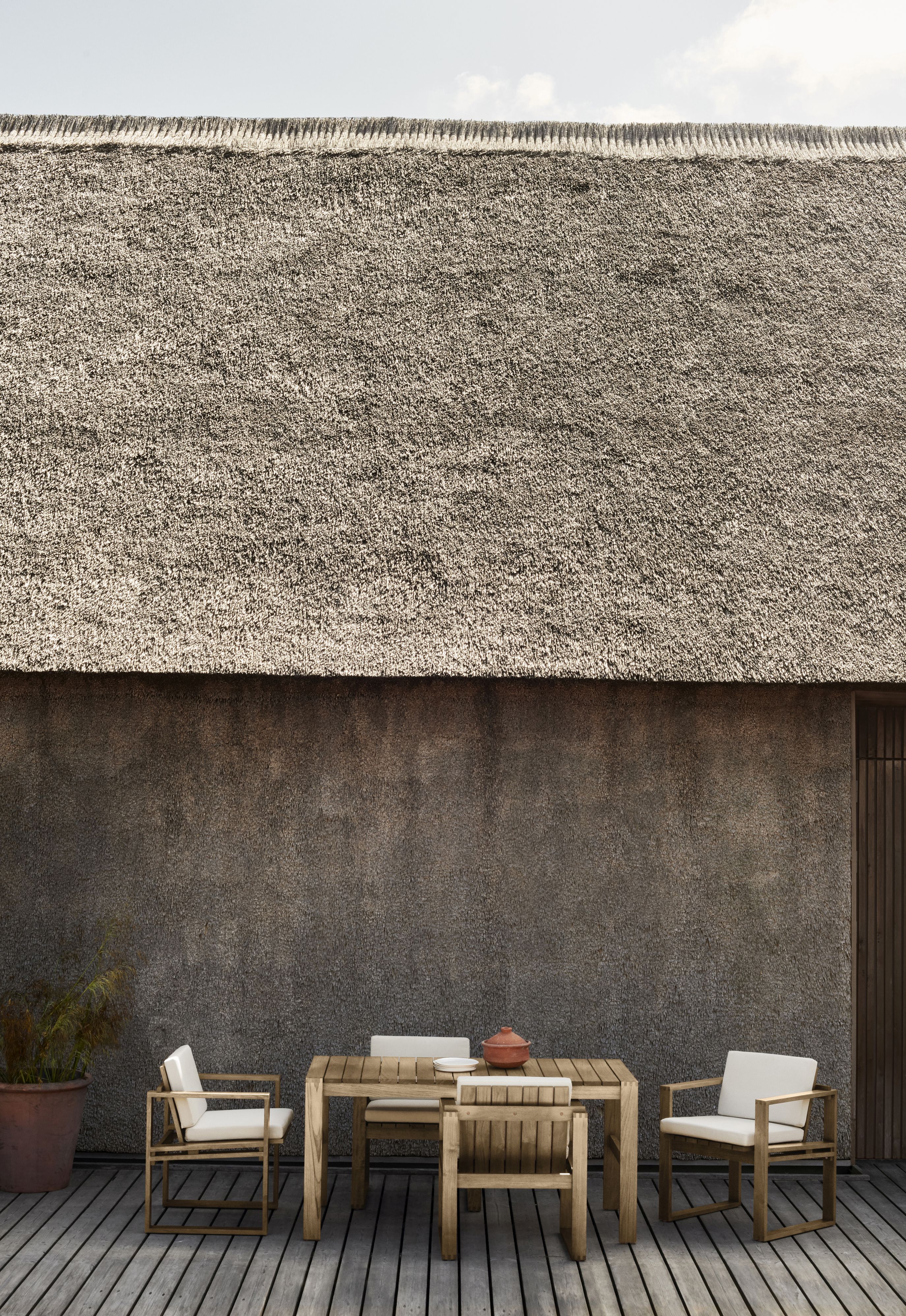 Bodil Kjaer Outdoorstuhl von Carl Hansen & Søn mit Tisch und Stühlen auf Holzterrasse.