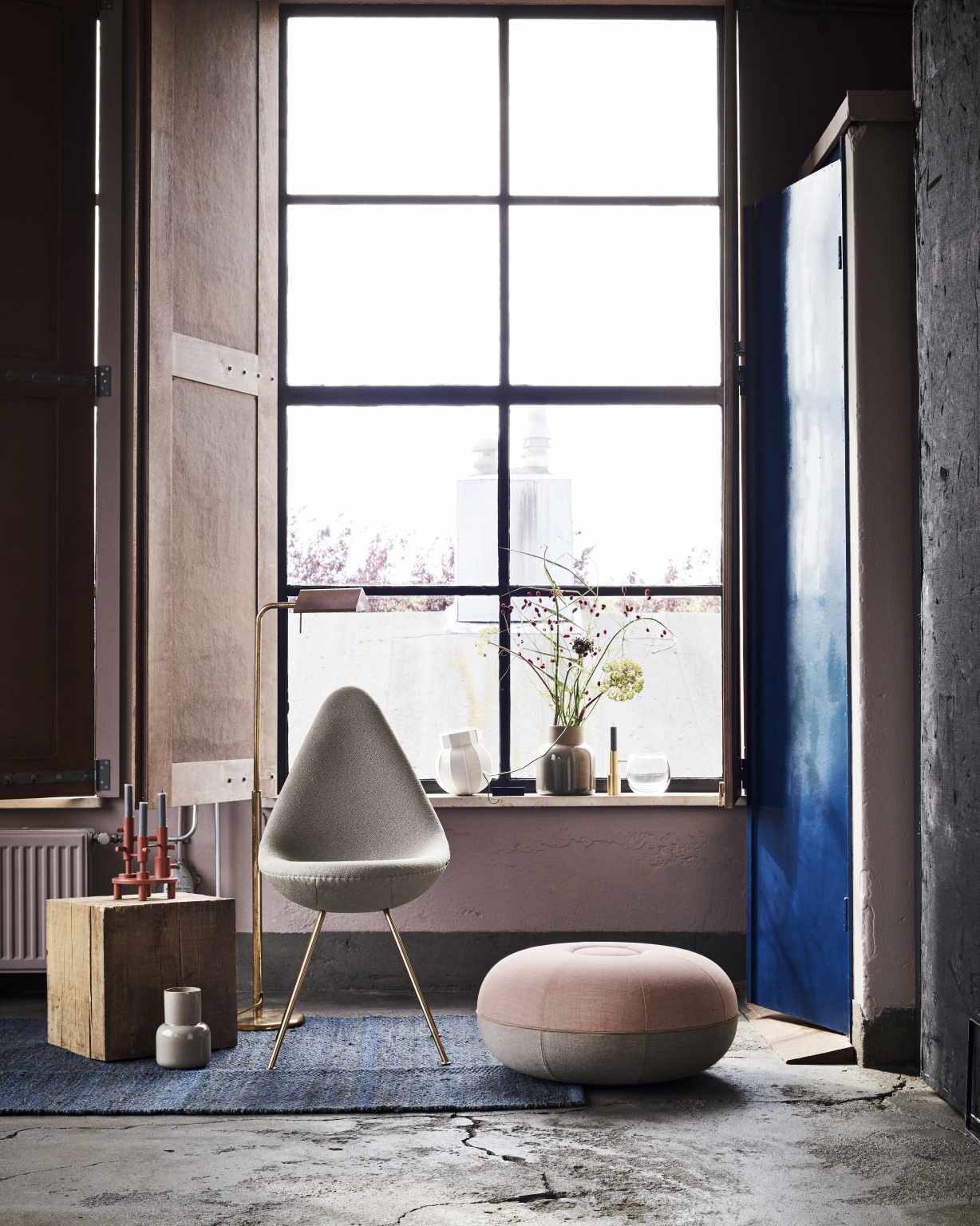Grauer Drop Stuhl von Fritz Hansen mit goldenen Beinen in modernem Interieur mit Fenster und Dekoration.