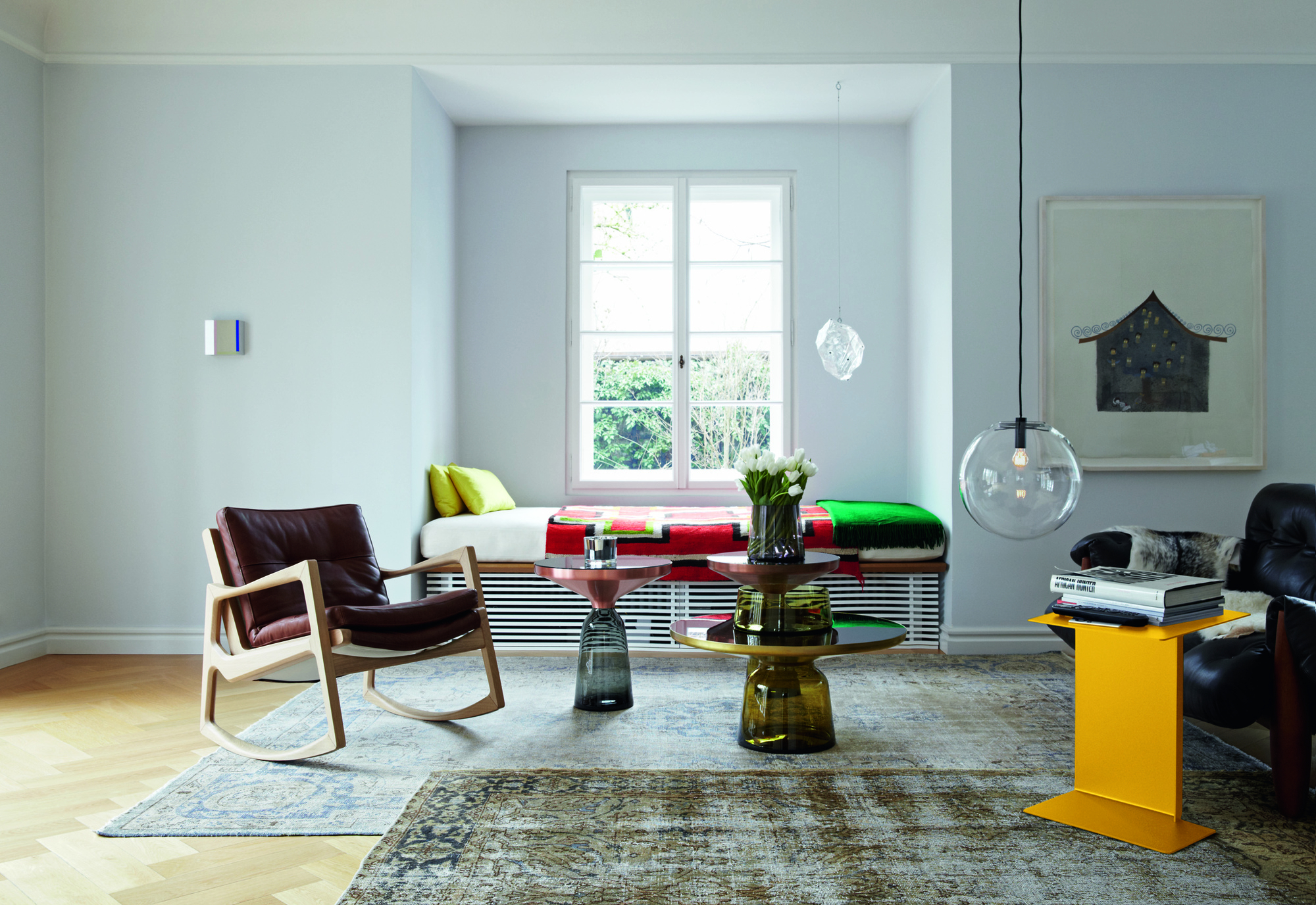 Wohnzimmer-Szene mit ClassiCon Bell Side Table Beistelltischen in Kupfer und Messing, sowie einem gelben Stahl Beistelltisch.