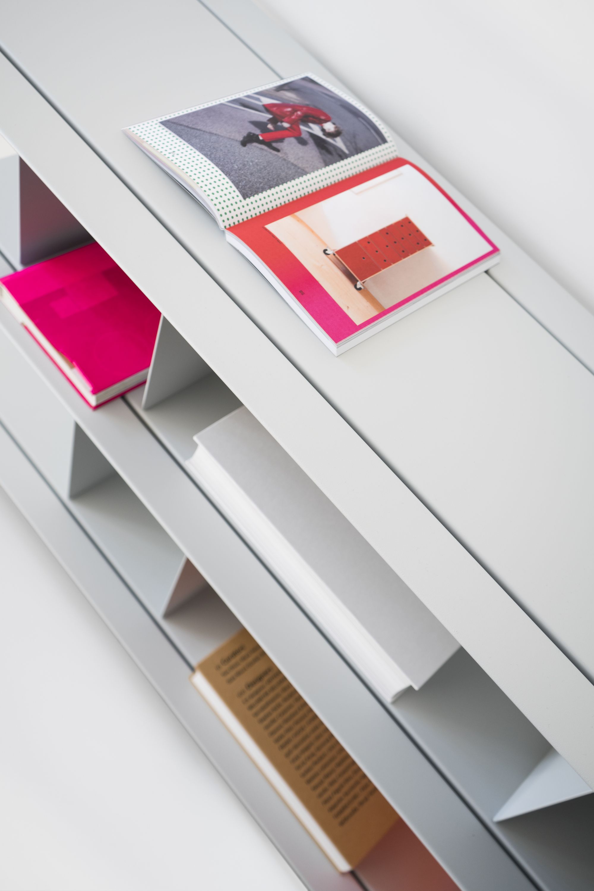 Detailaufnahme des Zoll D Regals von Nils Holger Moormann, grau, mit Büchern und Magazinen.