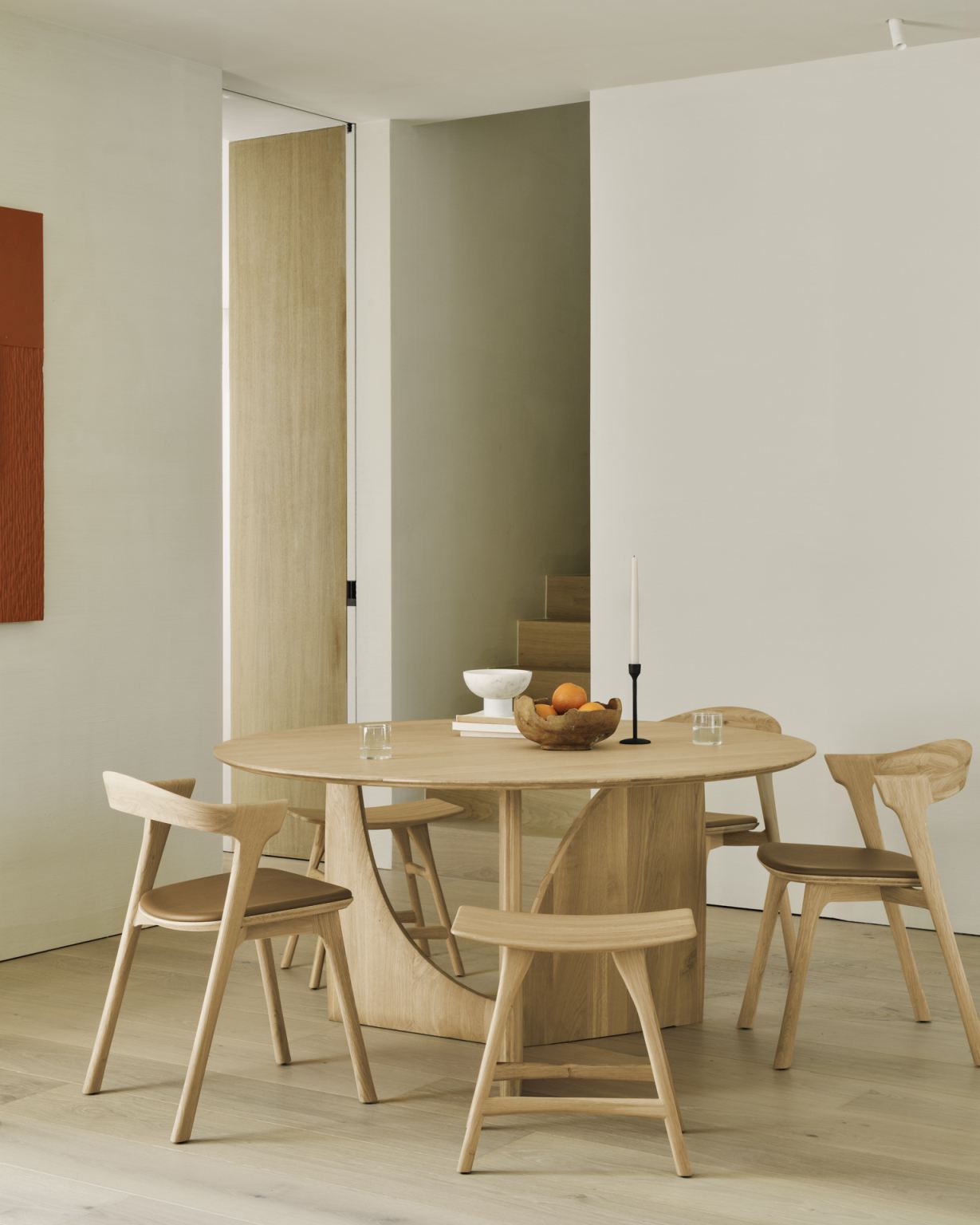 Ethnicraft Geometric Dining Table Esstisch aus Eiche, runder Holztisch mit Stühlen in modernem Esszimmer.