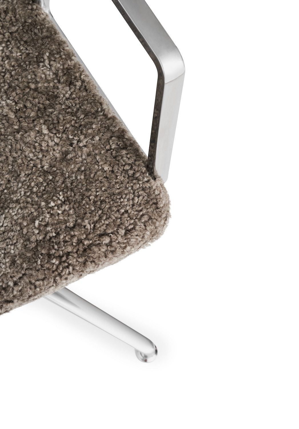 Detailaufnahme: Vipp Curly Stuhl mit braunem, lockigem Bezug und silbernem Metallgestell. Design Bürostuhl.
