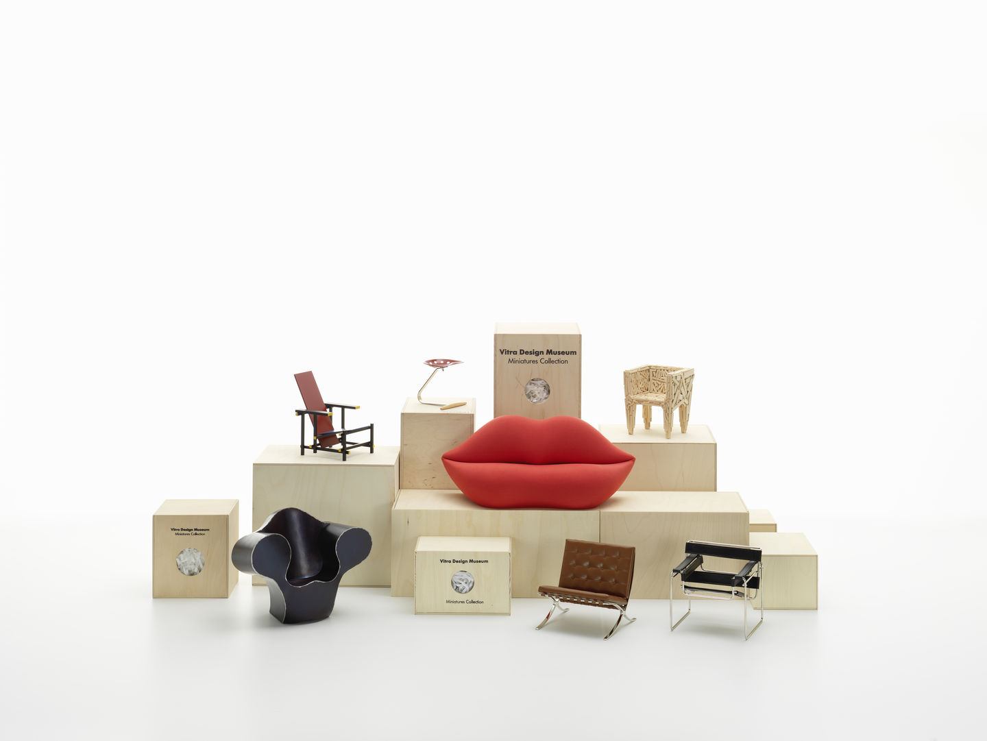 Produktfoto: Vitra Design Museum Miniaturen Kollektion, Miniatur Designermöbel auf Holzpodesten, rote Lippen Sofa.