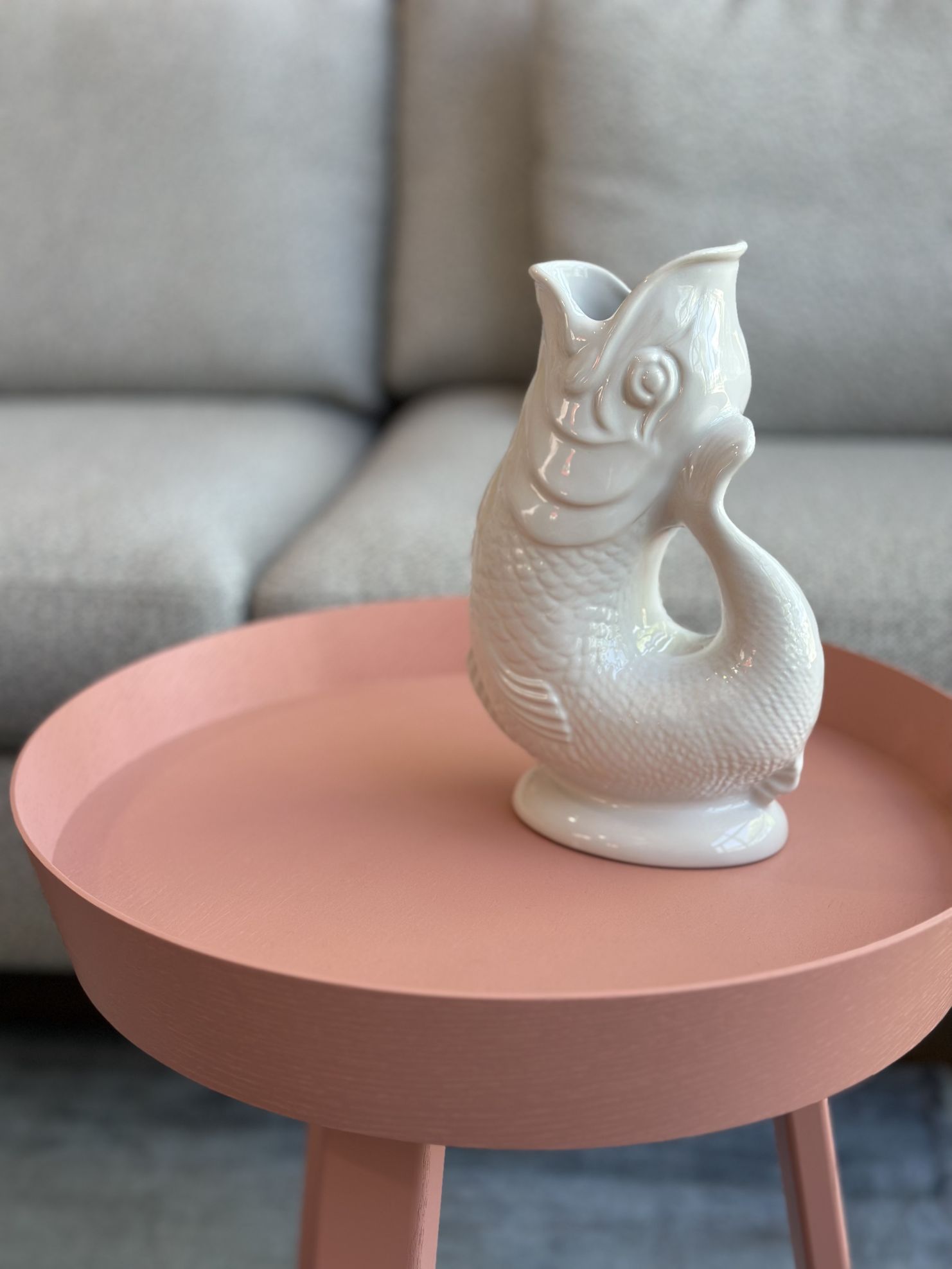 Weiße Gluckigluck Fischkaraffe XL auf einem rosa Tisch, dekorative Keramik Vase in Fischform.
