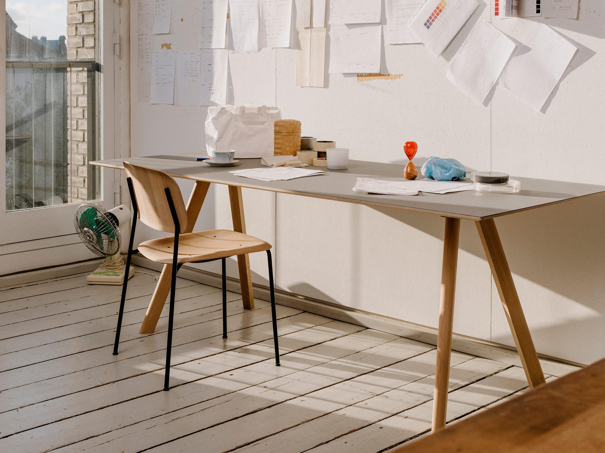 Hay Copenhague CPH 30 Tisch mit grauem Linoleum und Holzbeinen in einem hellen, modernen Arbeitszimmer.