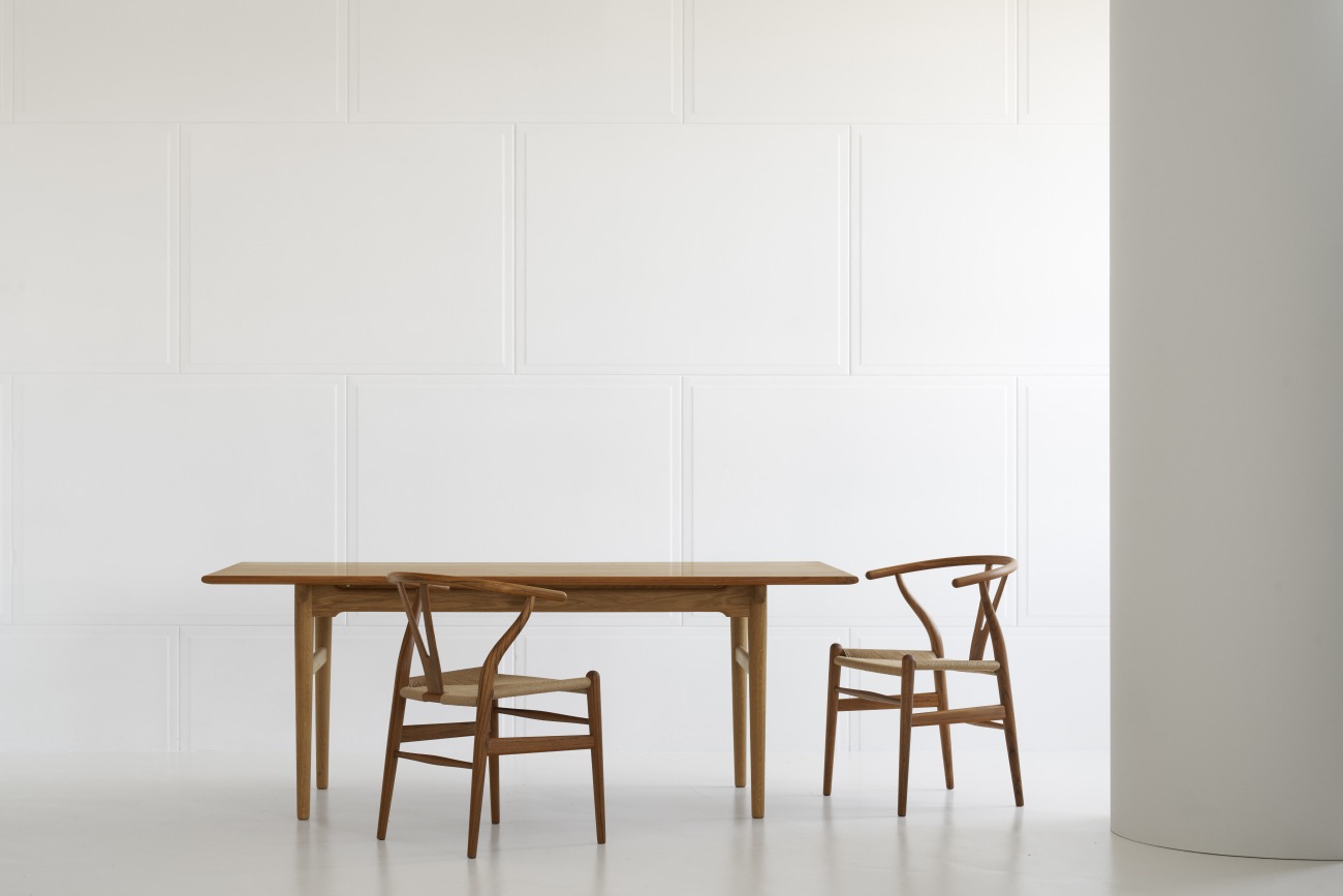 CH24 Wishbone Chair aus Teakholz von Carl Hansen & Søn mit Esstisch in minimalistischem Ambiente.
