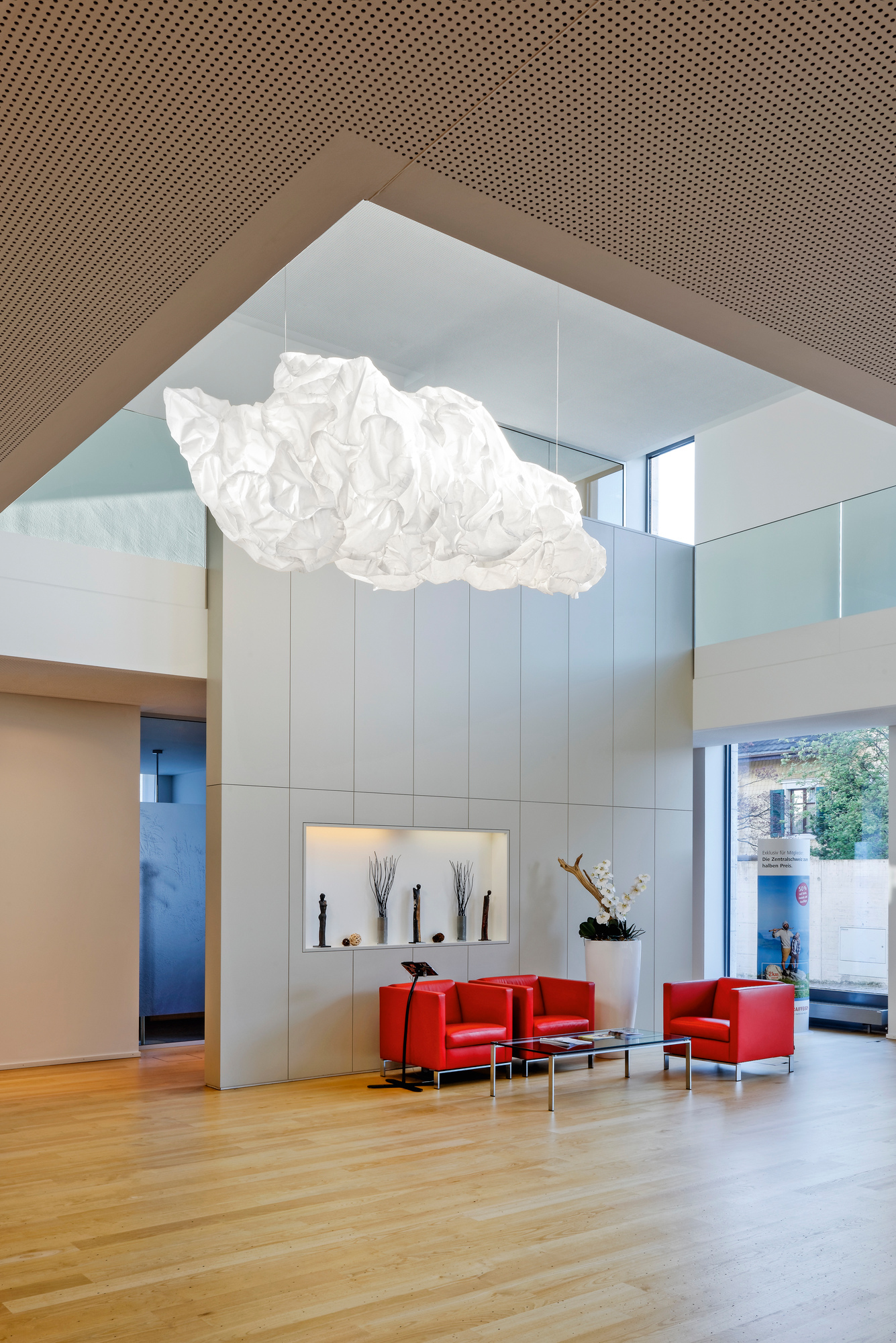 Helle Mamacloud Pendelleuchte von Belux, eine moderne LED-Lampe in Wolkenform, hängt in einem Raum.