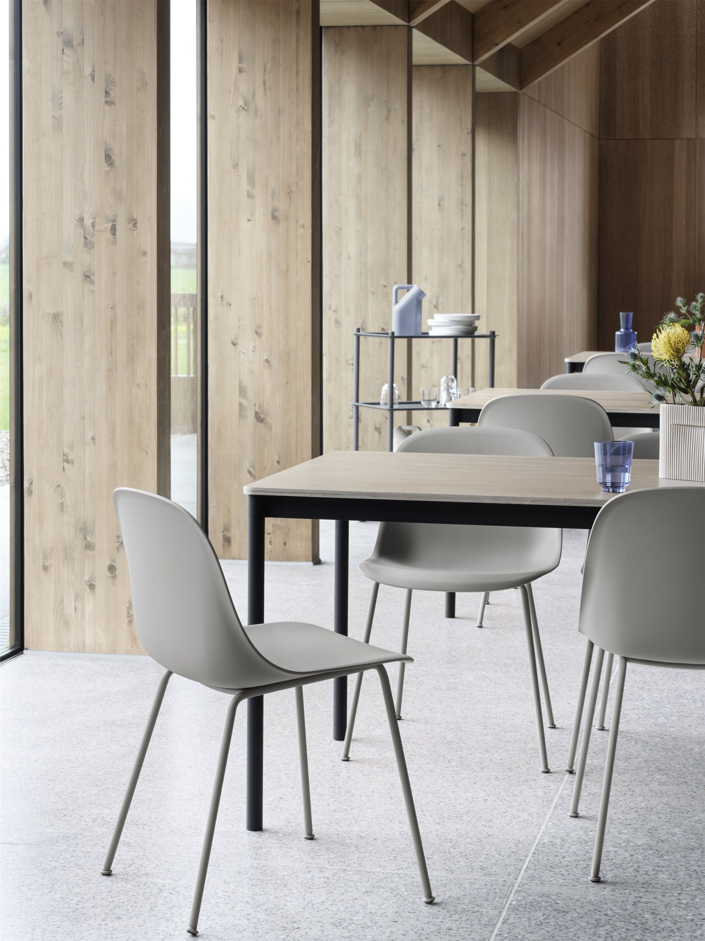 Helle Inneneinrichtung mit mehreren Fiber Side Chair Stühlen von Muuto an Tischen, minimalistisches Design.