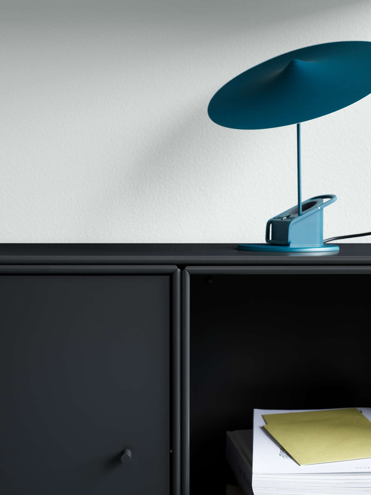 Detailaufnahme: Graues Montana Mini Modul mit Tür und blauer Lampe. Stauraum für Wohnzimmer.