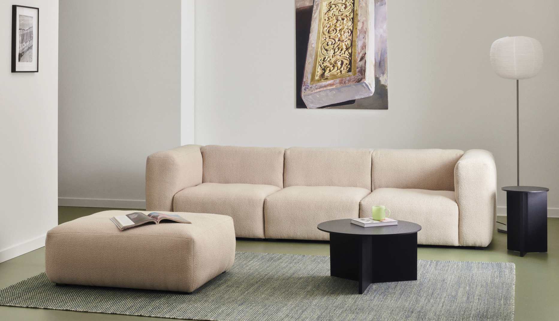 Beige Mags Soft Sofa 3-Sitzer mit Hocker und schwarzem Couchtisch auf einem Teppich.