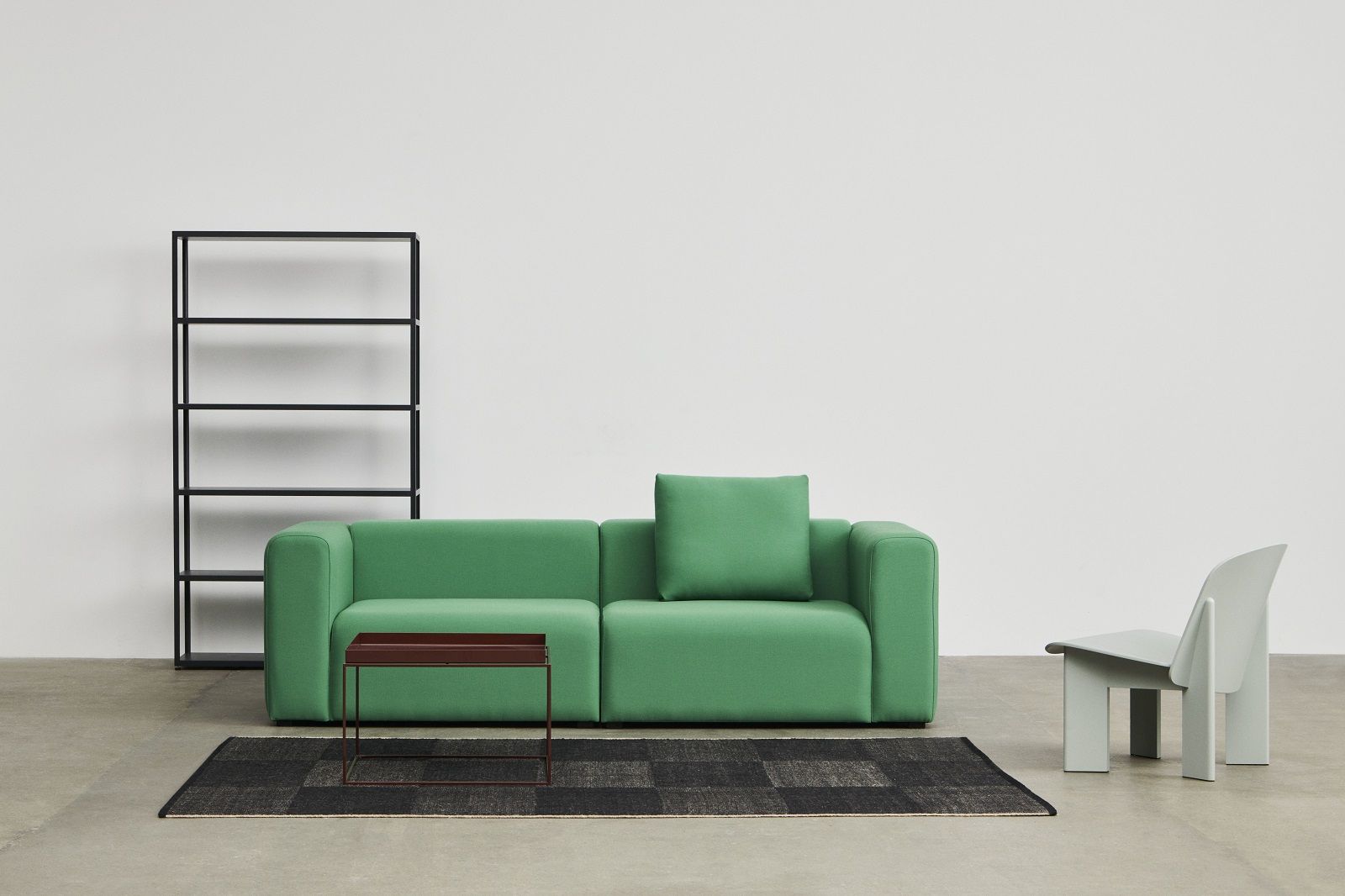 Hay Tray Table Couchtisch in Braun vor einem grünen Sofa, Regal und Stuhl.