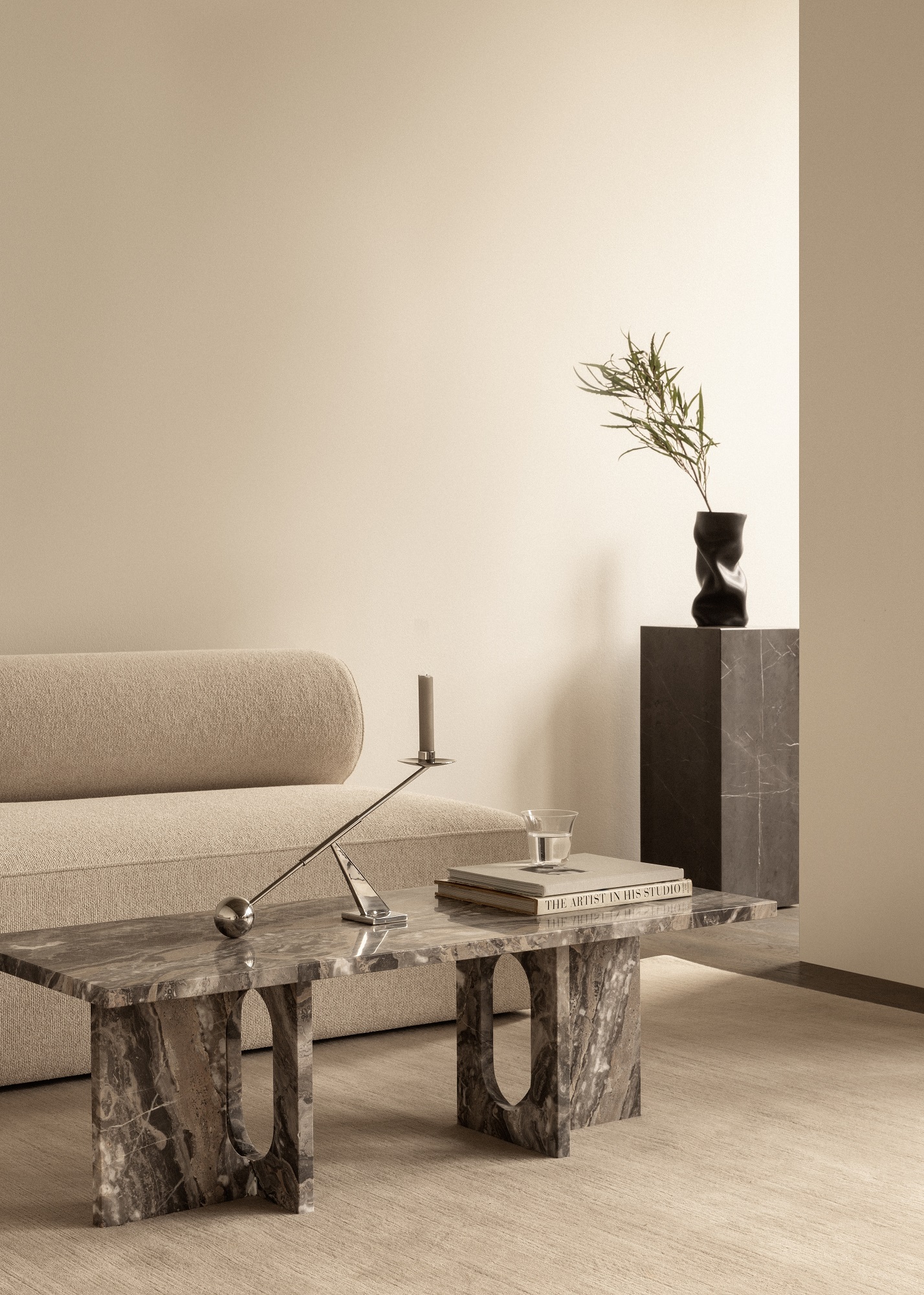 Androgyne Couchtisch von Audo Copenhagen aus Marmor, mit Kerzenständer, Buch und Dekoration.
