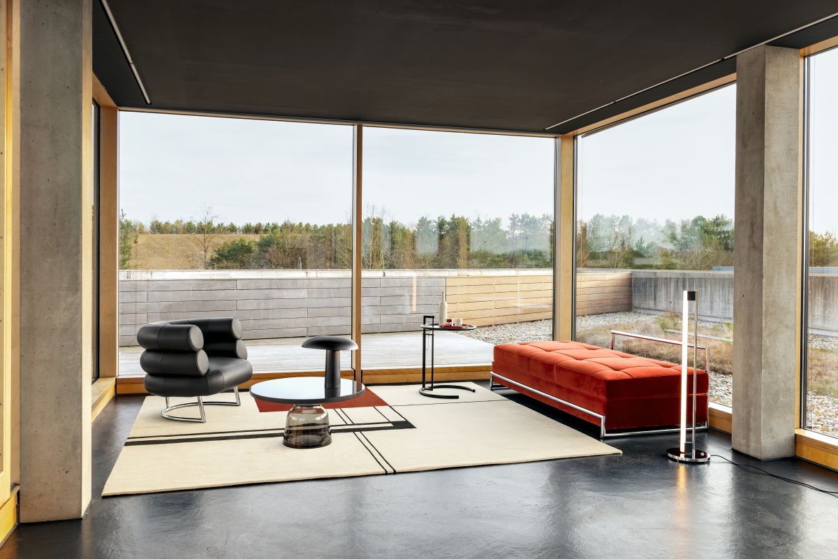 Helle, moderne Inneneinrichtung mit ClassiCon Forma Tischleuchte, Sessel, Sofa und großem Fenster mit Ausblick.