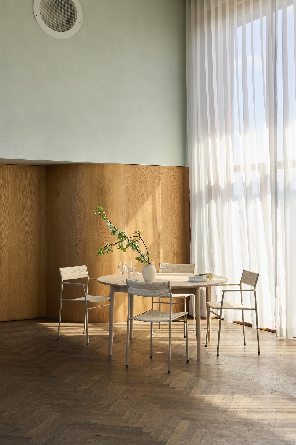 Vier Vev Dining Stühle von Northern um einen runden Esstisch in einem hellen Raum.