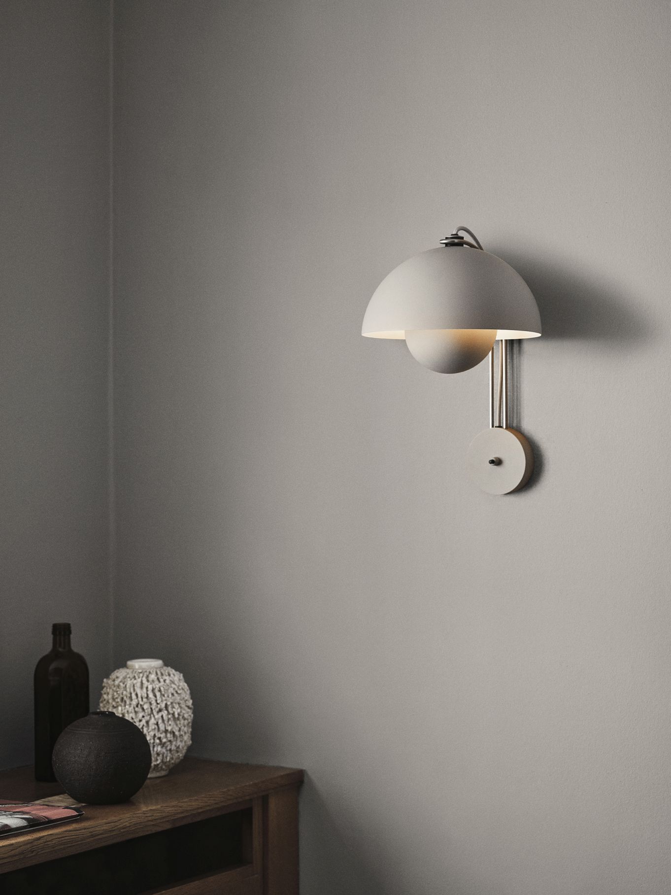 Nahaufnahme der grauen Flowerpot VP8 Wandleuchte von AndTradition an einer Wand.