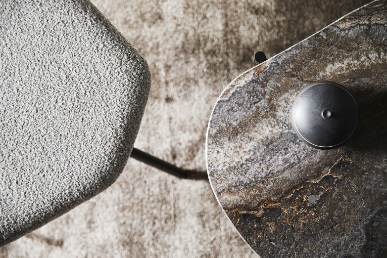 Detailaufnahme des Woud Tint Rug Teppichs (200x300 cm) in Beige, kombiniert mit Stuhl und Tisch.