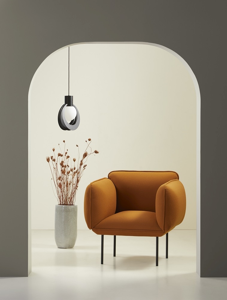 Lunar Pendelleuchte von Woud über Sessel und Vase mit Trockenblumen, modernes Wohnzimmer Interieur.