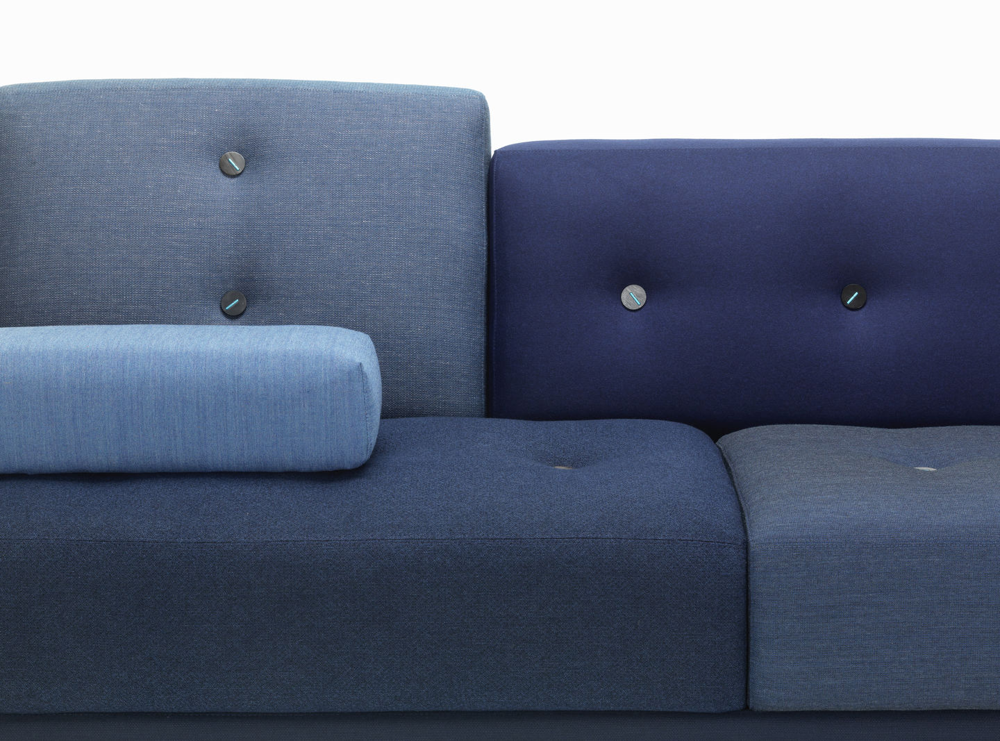Detailaufnahme vom blauen Vitra Polder Sofa mit Knopfdetails und Zierkissen, modernes modulares Design.