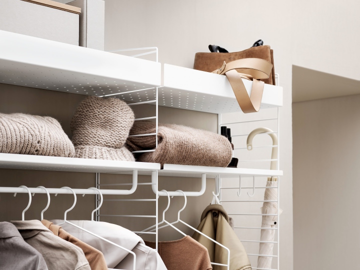 Flur String Möbel: Weißes Regalsystem mit Kleidung, Accessoires und Dekoration für eine stilvolle Flurgestaltung.