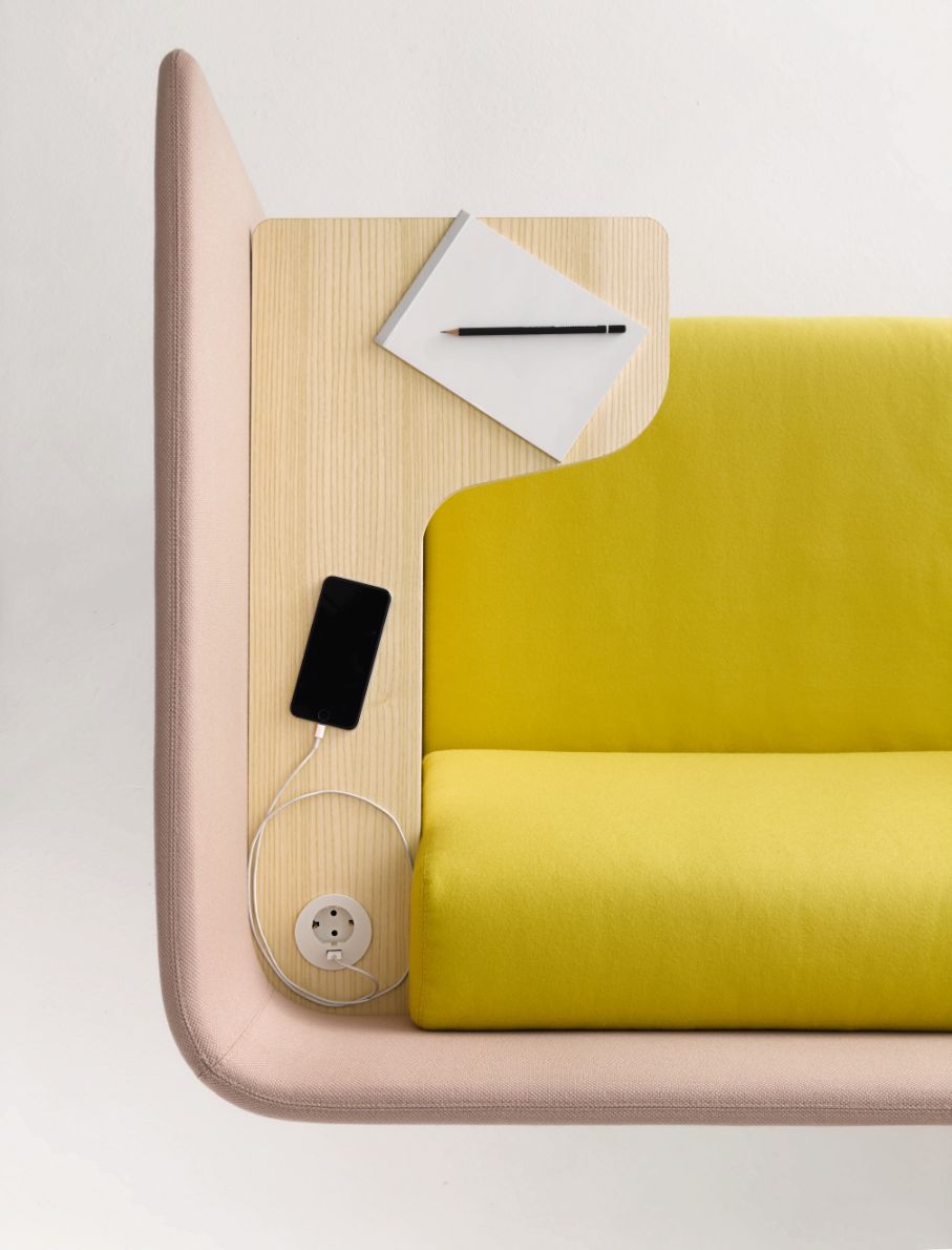Detailaufnahme des Floater Sofas von Cor in Gelb und Rosa mit integrierter Ladestation und Ablagefläche.