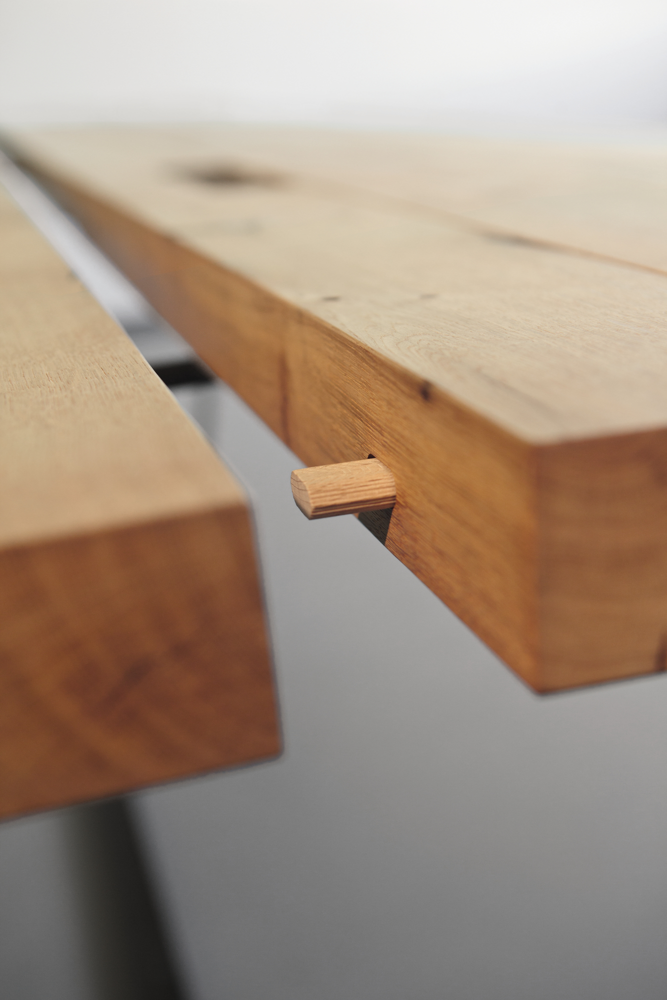 Detailaufnahme des Janua BB 11 Clamp Tischs in Eiche gekalkt, Fokus auf die Holzverbindung.