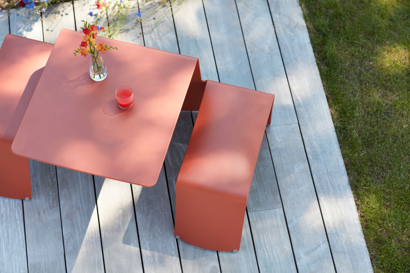 Picnik Tisch-Bank-Kombination von Extremis in Terrakotta auf Holzterrasse, ideal für den Garten.