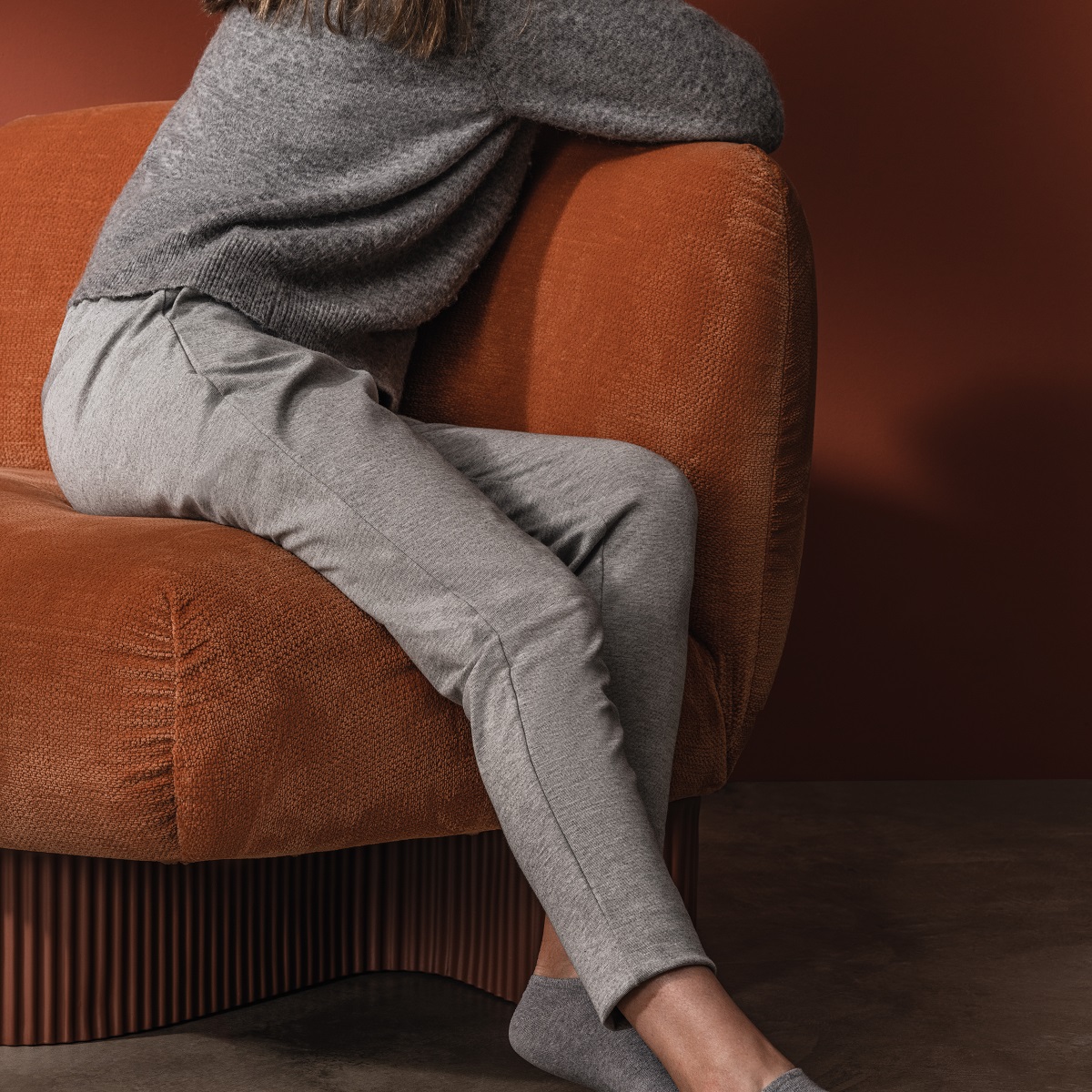 Frau entspannt auf orangefarbenem Bolete Lounge Sessel von Andreu World, bequemes modulares Sofa für Wohnzimmer.