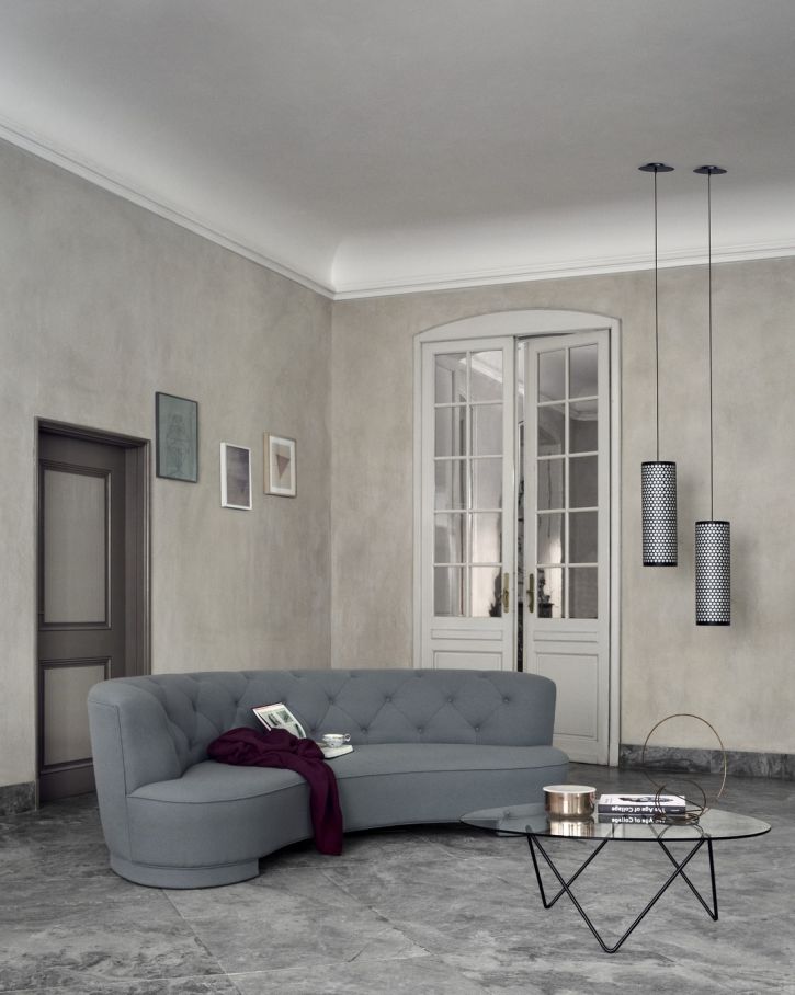 Wohnzimmer mit grauem Sofa und Gubi Pedrera Couchtisch mit Glasplatte und schwarzem Gestell.