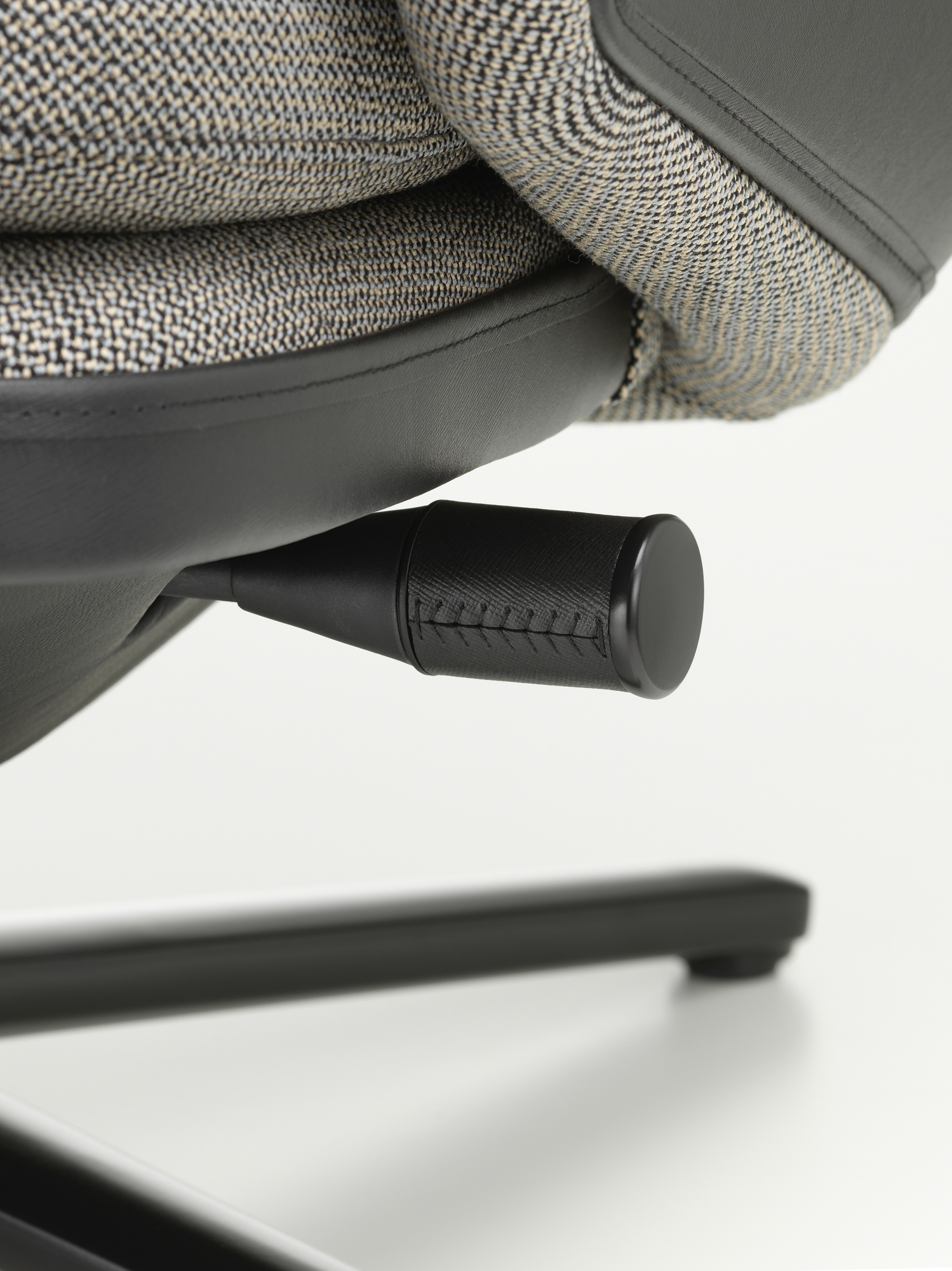 Detailaufnahme des Vitra Grand Relax Sessels: Verstellmechanismus, Stoffbezug und Lederakzente des Designersessels.