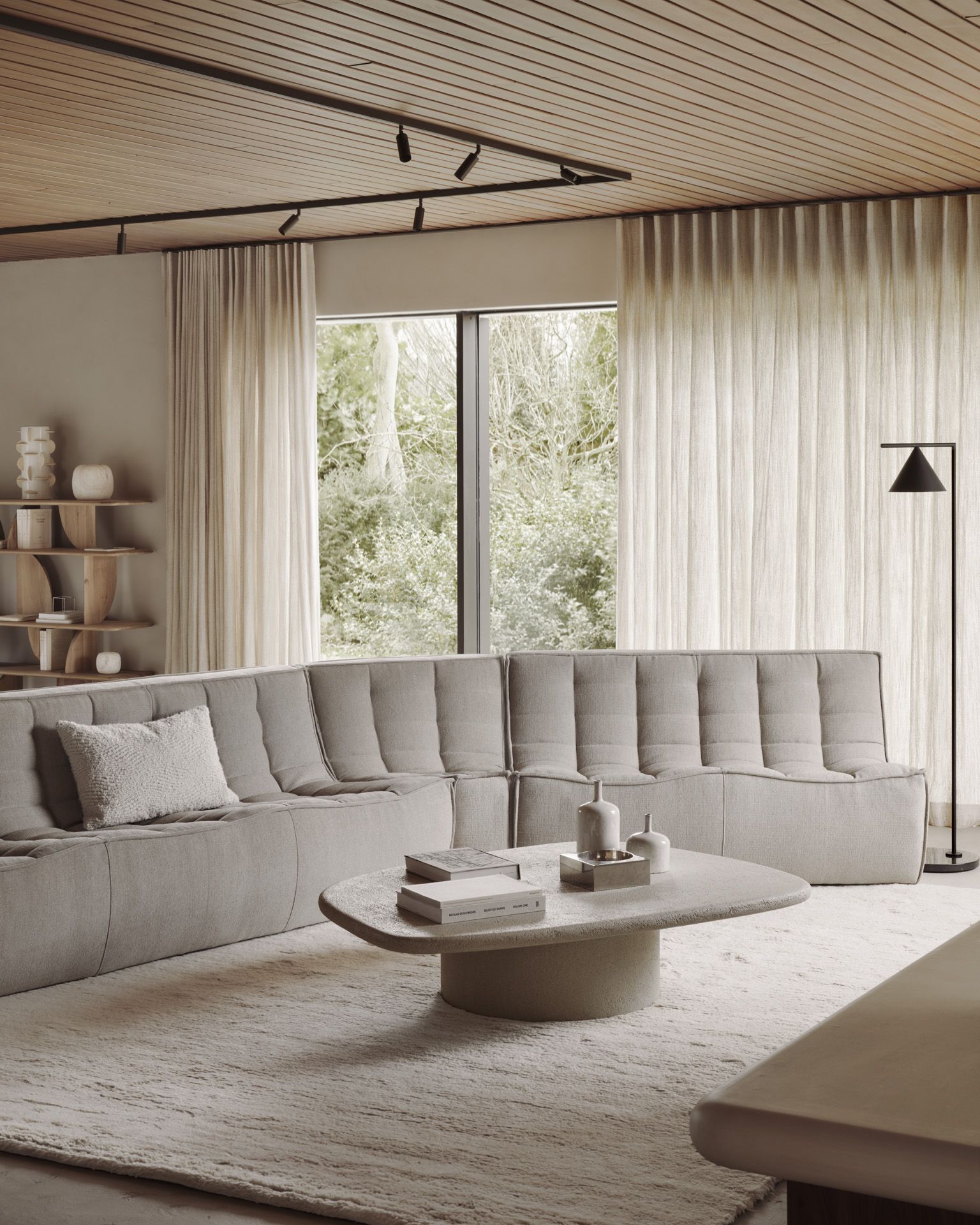 Elements Couchtisch von Ethnicraft: Kieselform Microcement Couchtisch in einem hellen Wohnzimmer mit Sofa.