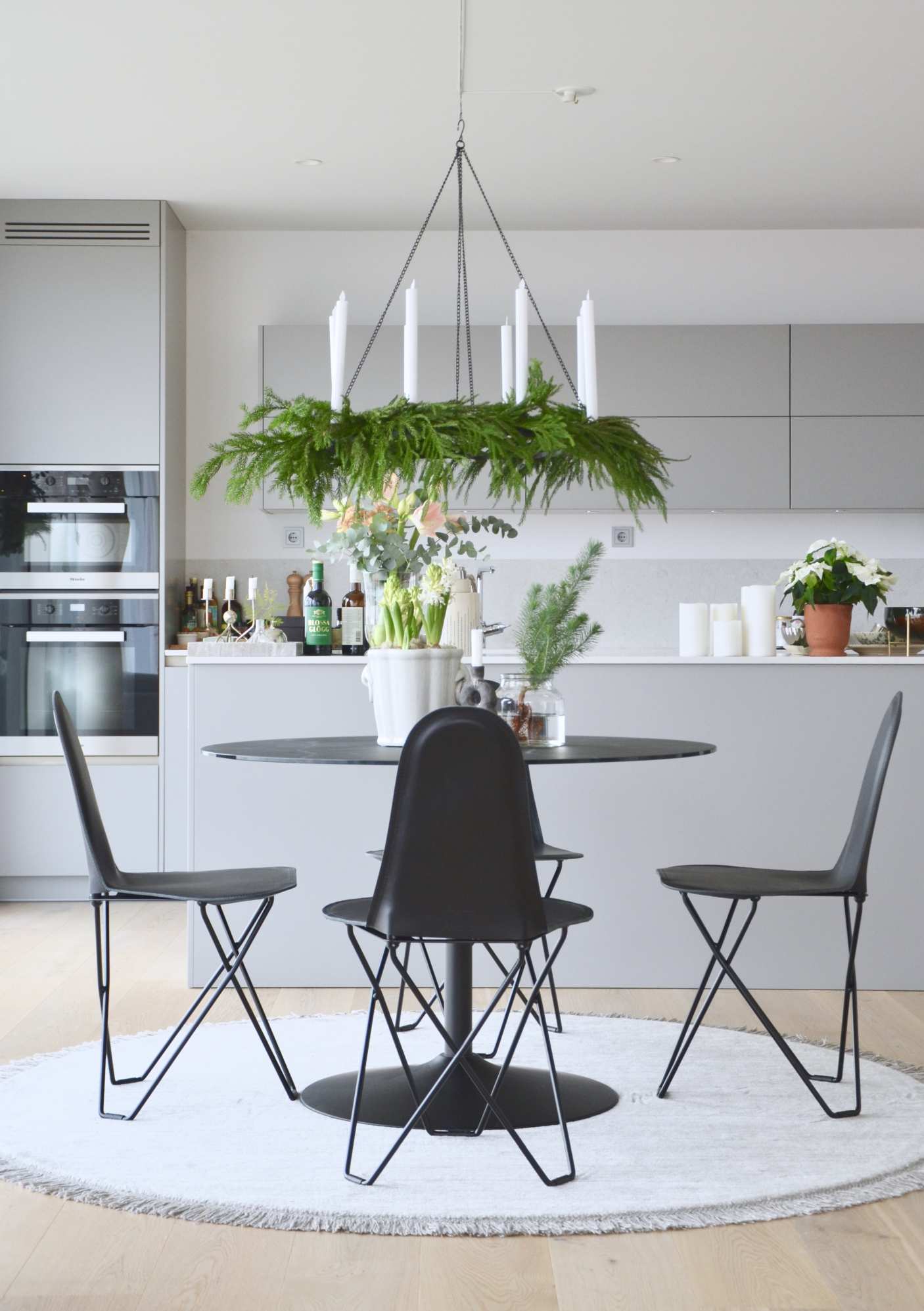 Schwarze Cactus Stühle mit Lederbezug um runden Tisch in moderner Küche. Designermöbel für Esszimmer.